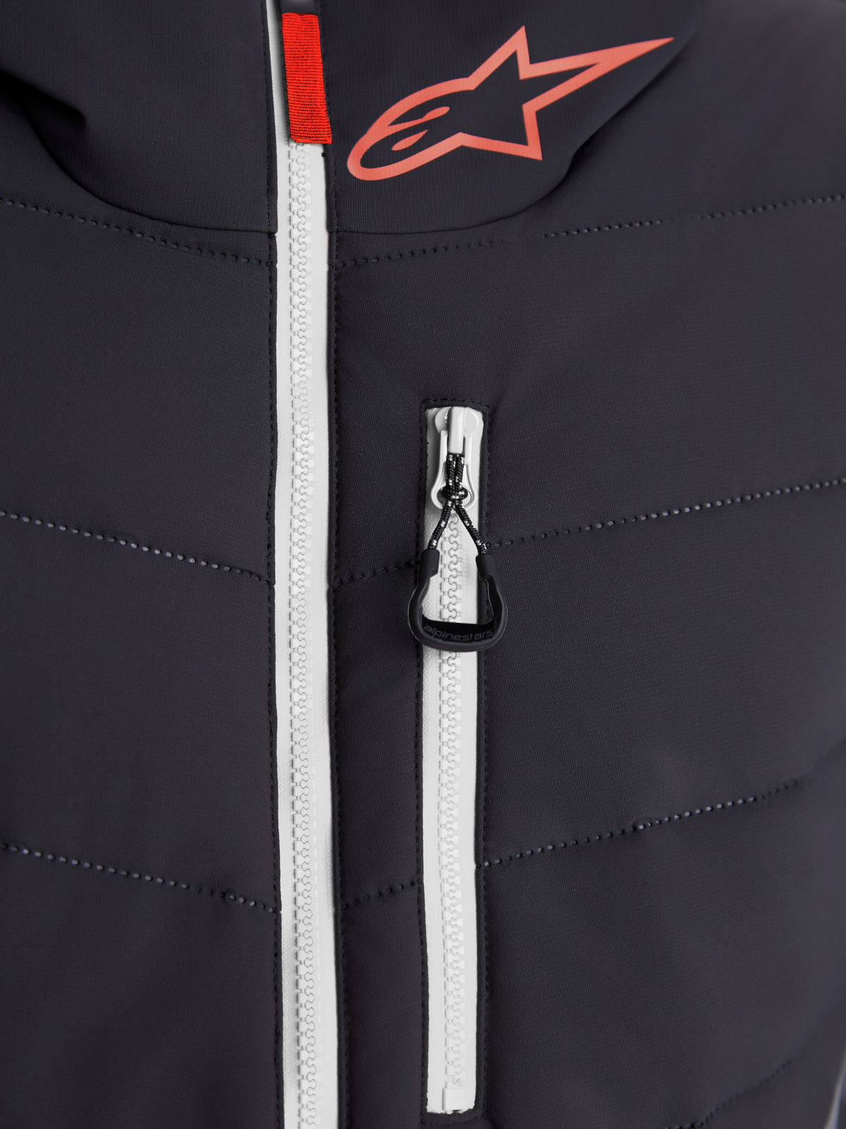 Alpinestars Therma-Tech vattentät jacka, urban samtida motorcykeljacka, närbild av svetsad dunjackekonstruktion, vit vattentät huvuddragkedja och Alpinestars-logotyp, svart och mörkgrå med röda detaljer