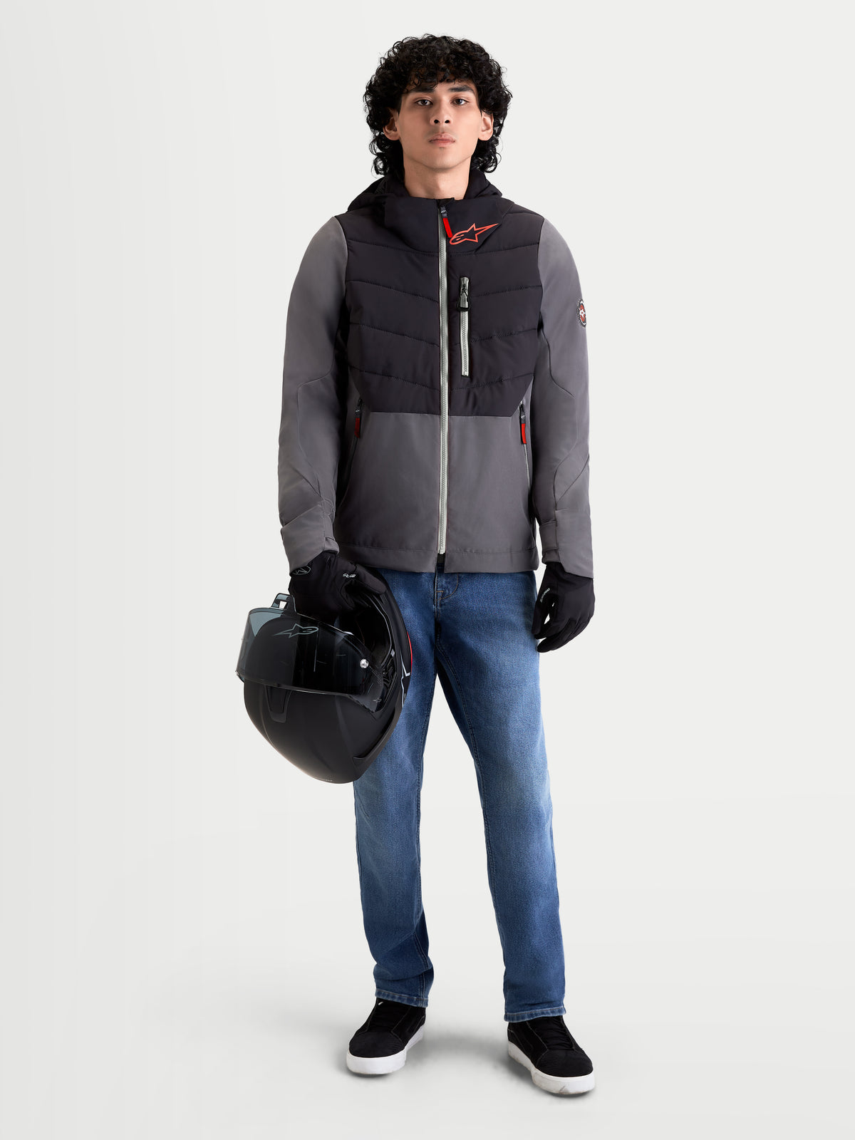 Alpinestars Therma-Tech vattentät jacka, urban contemporary motorcykeljacka för herr, svart och mörkgrå, framifrån på modell som bär jeans, handskar och håller en hjälm