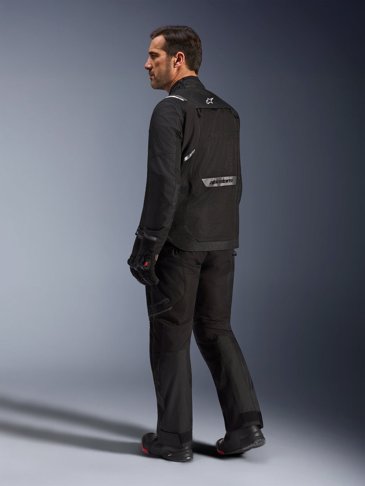 Alpinestars Cusco Drystar® jacka, motorcykeljacka för adventure touring, herrmodell, svart, textil, sedd bakifrån med reflekterande logotyp.