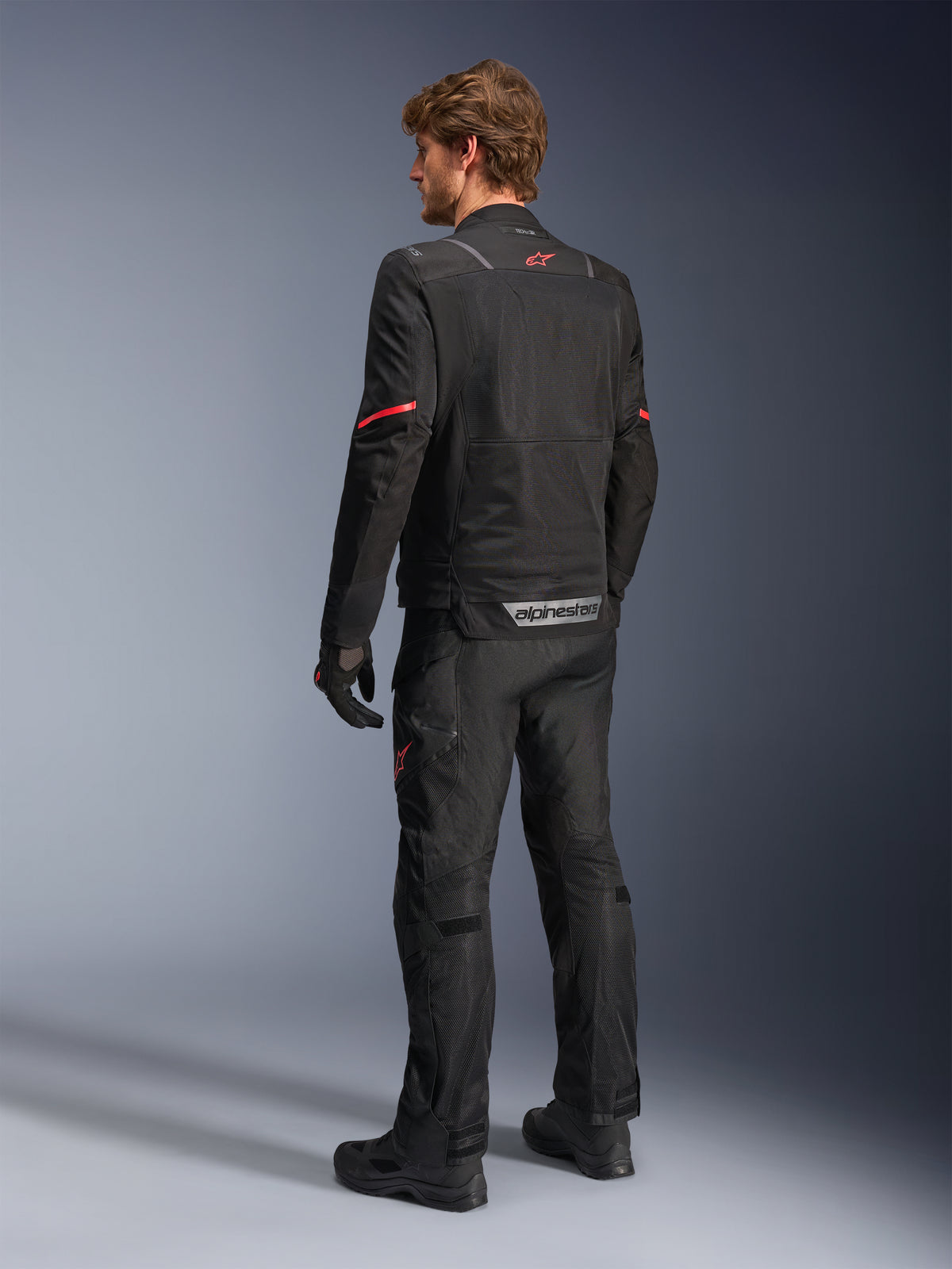 Alpinestars ST-2 Air Jacket, black adventure touring motorcycle jacket for men, mesh panels, red star logo, rear view.