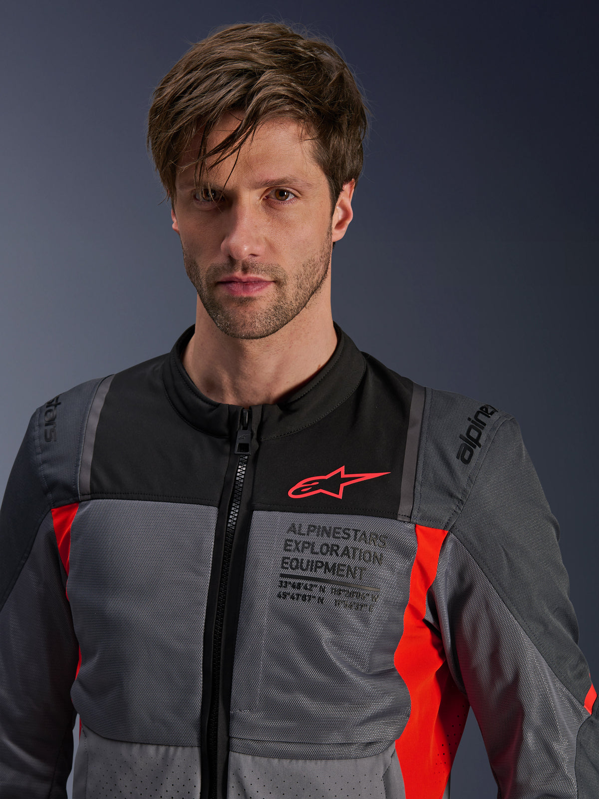Alpinestars ST-2 Air jacka, grå och röd herr-mc-jacka i textil för touring med meshventilation, bärs av en modell.