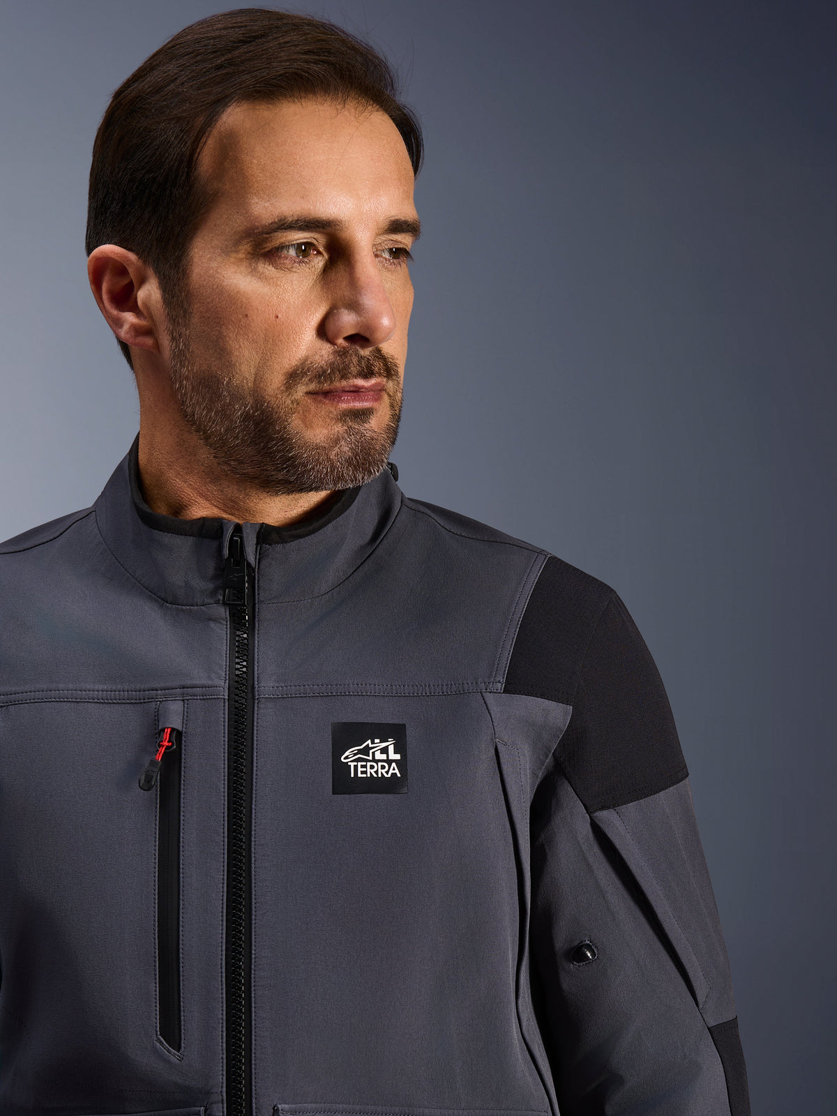 Alpinestars Maxdura Drystar®XF Laminated Armored Shell, Technical Adventure Jacket, Deep Gray and Black, featuring 'ALL TERRA' branding on the chest, waterproof chest zipper with red accent, and high-performance textile design for adventure motorcycling
