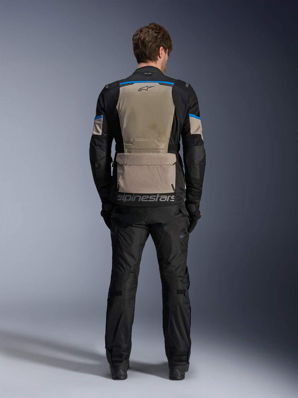 Alpinestars Andes Air Drystar®-jacka, Black Laurel Gray Bright Blue, vy bakifrån som visar en stor ventilationspanel i mesh, rymlig förvaringsficka på nedre delen av ryggen med Alpinestars-logotyp, teknisk motorcykeljacka för touring buren med matchande byxor.
