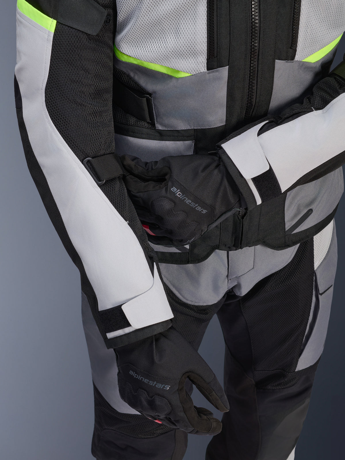 Alpinestars Andes Air Drystar® Jacket, Motorcycle Touring Jacket, Ice Gray and Dark Gray with Neon Yellow accents, close-up showing mesh panels and adjustment straps, worn with black Alpinestars gloves
