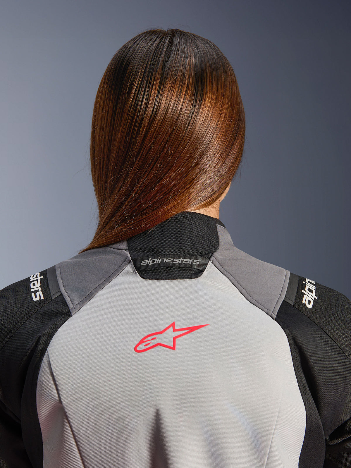 Alpinestars Stella Andes V4 Drystar äventyrsjacka för dam, isgrå och svart med korallrosa rygglogotyp, närbild bakifrån.