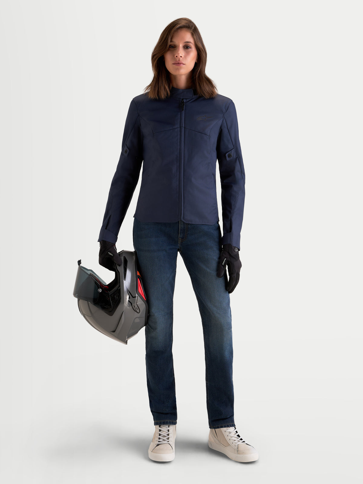 Alpinestars Stella C 1 Waterproof jacka, damns motorcykeljacka i blått, bärs av en modell som håller i en hjälm, med slitstark polyamidtextilkonstruktion