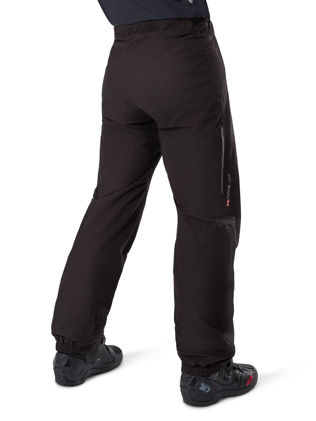 Alpinestars Amt-8 Stretch Drystar® XF byxfoder, svart, vy bakifrån som visar det vattentäta fodret buret över svarta motorcykelstövlar, med Drystar XF-logotyp på underbenet, elastiska benslut och lätt stretchmaterial för adventure touring.