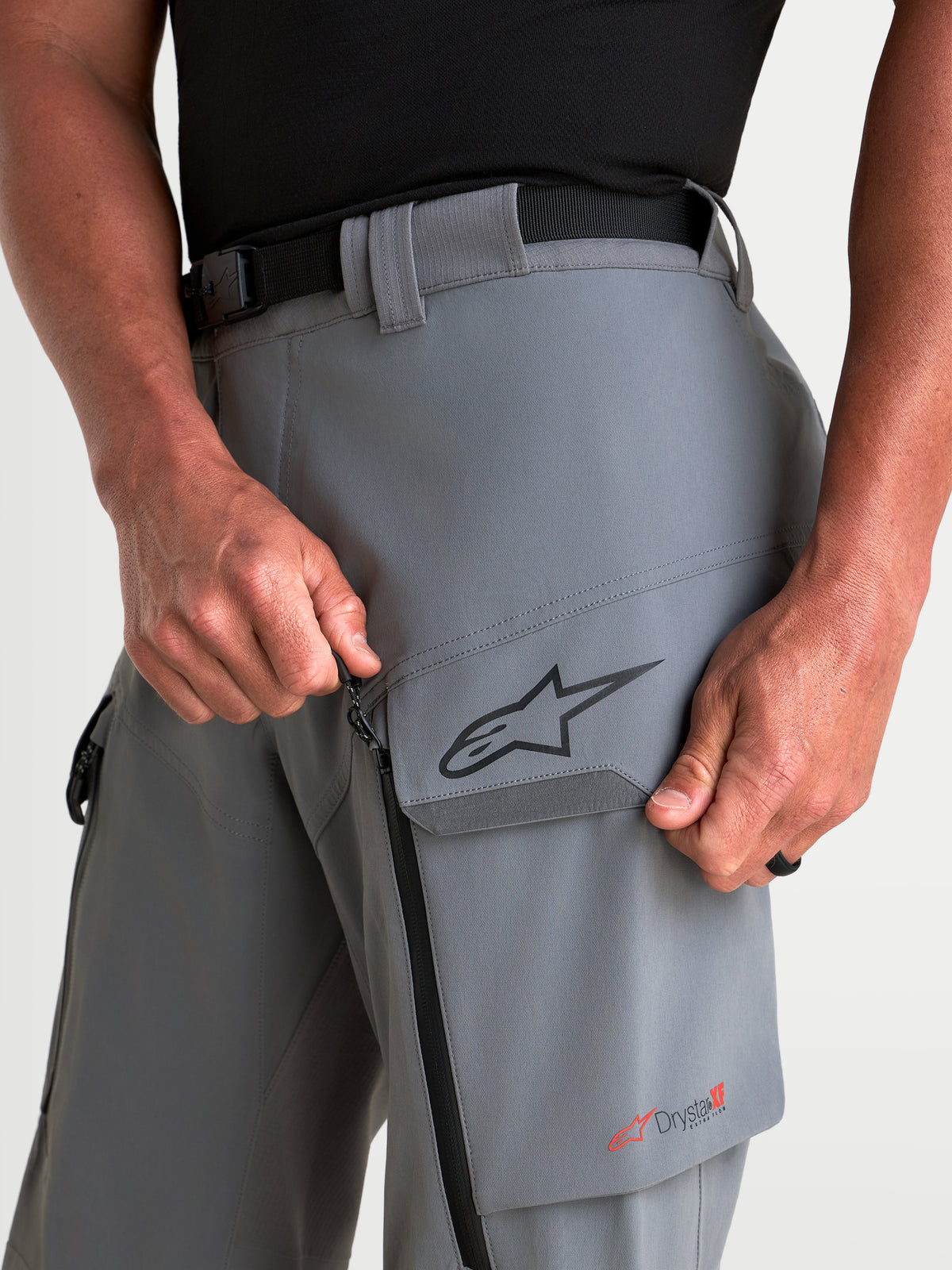Alpinestars Maxdura Drystar XF lanserade byxor, äventyrsmotorcykelbyxor för herr, mörkgrå, med lårficka, blixtlåsförsedd ventilation och närbild av Drystar XF-logotyp