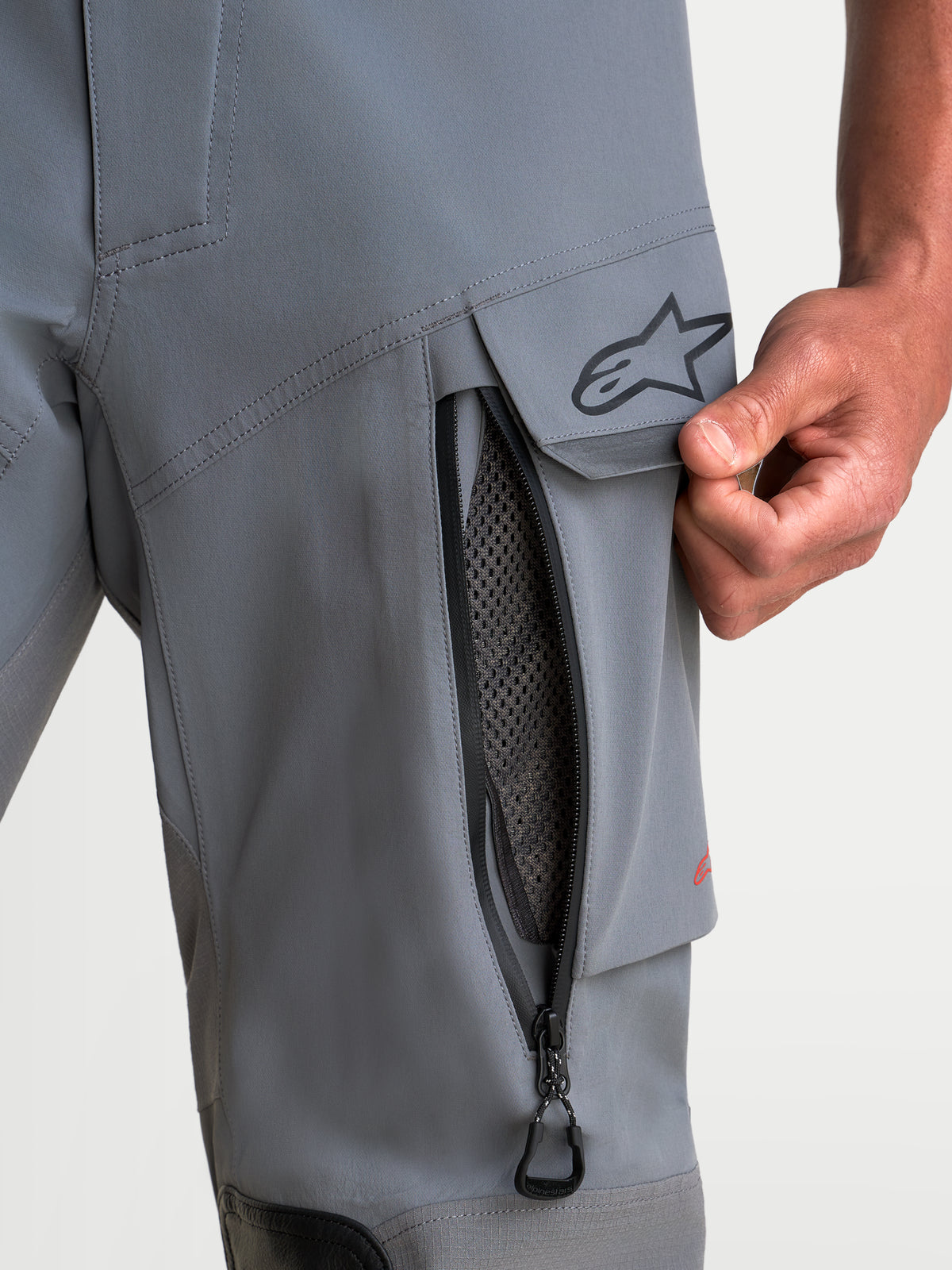 Alpinestars Maxdura Drystar XF Laminated byxor, mörkgrå och svarta äventyrsmotorcykelbyxor för herr, närbild på dragkedja för lårventilation och vattentålig cargoficka med A-star-logotyp, CE AA-certifierade