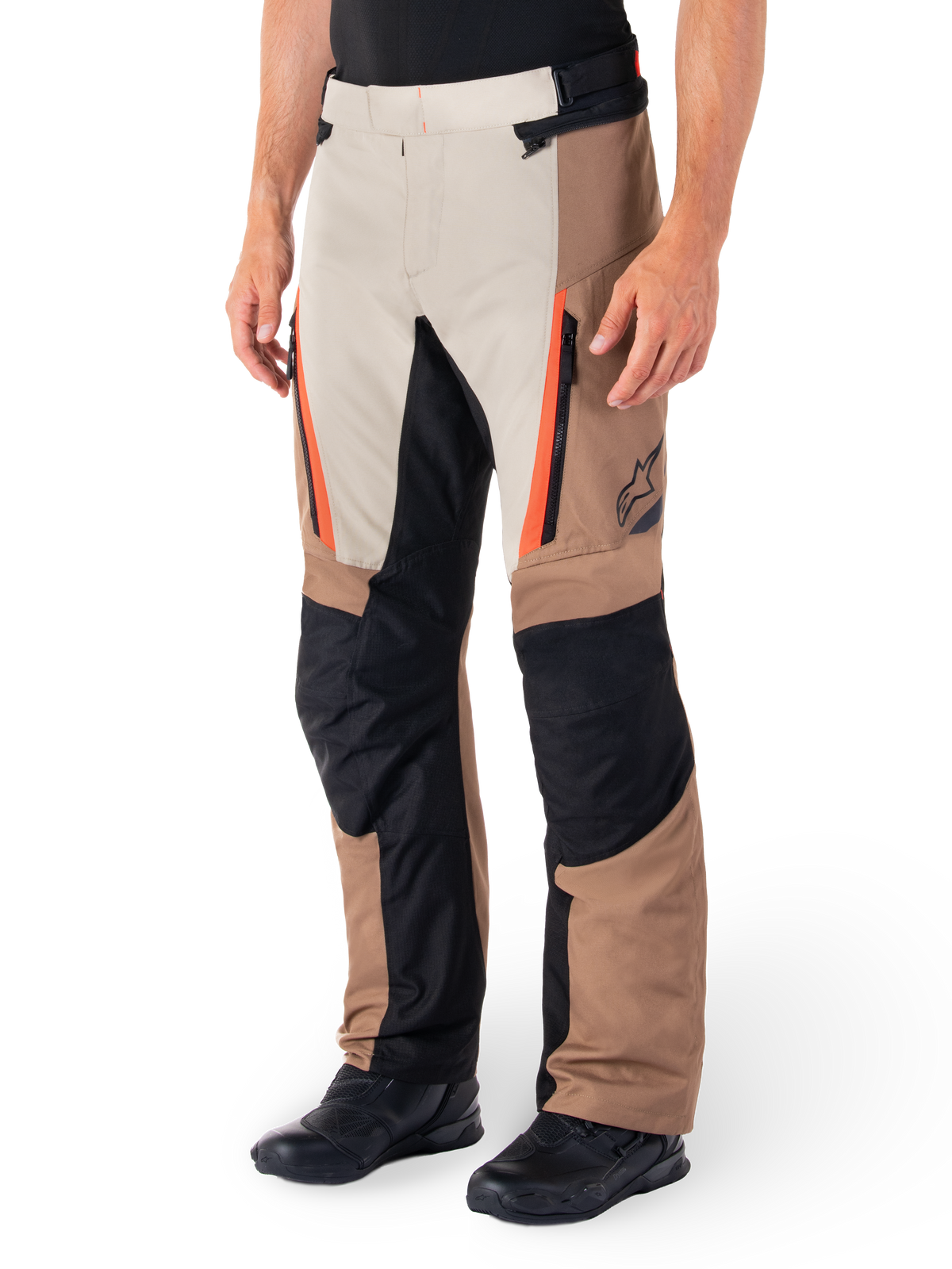 Alpinestars ST-1 Waterproof Pants, Adventure Touring Pants, Dark Khaki Sand Black and Red Fluo, featuring zippered front pockets and black reinforced panels on the knees and inner legs, worn with black riding shoes, ergonomic textile design for all-weather riding
