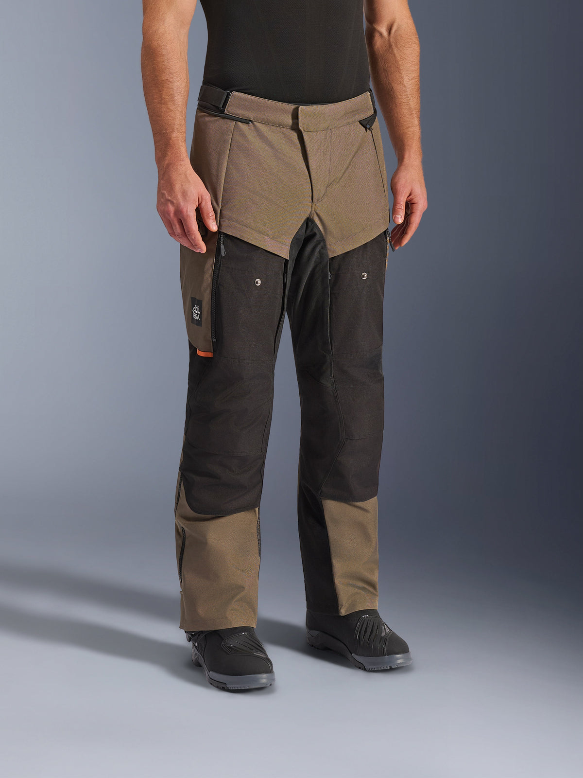 Alpinestars Cusco Drystar® Pants, Adventure Motorcycle Pants, Walnut Black, shown on a model with black boots, featuring a brown and black multi-panel design with zippered pockets and reinforced knees for touring