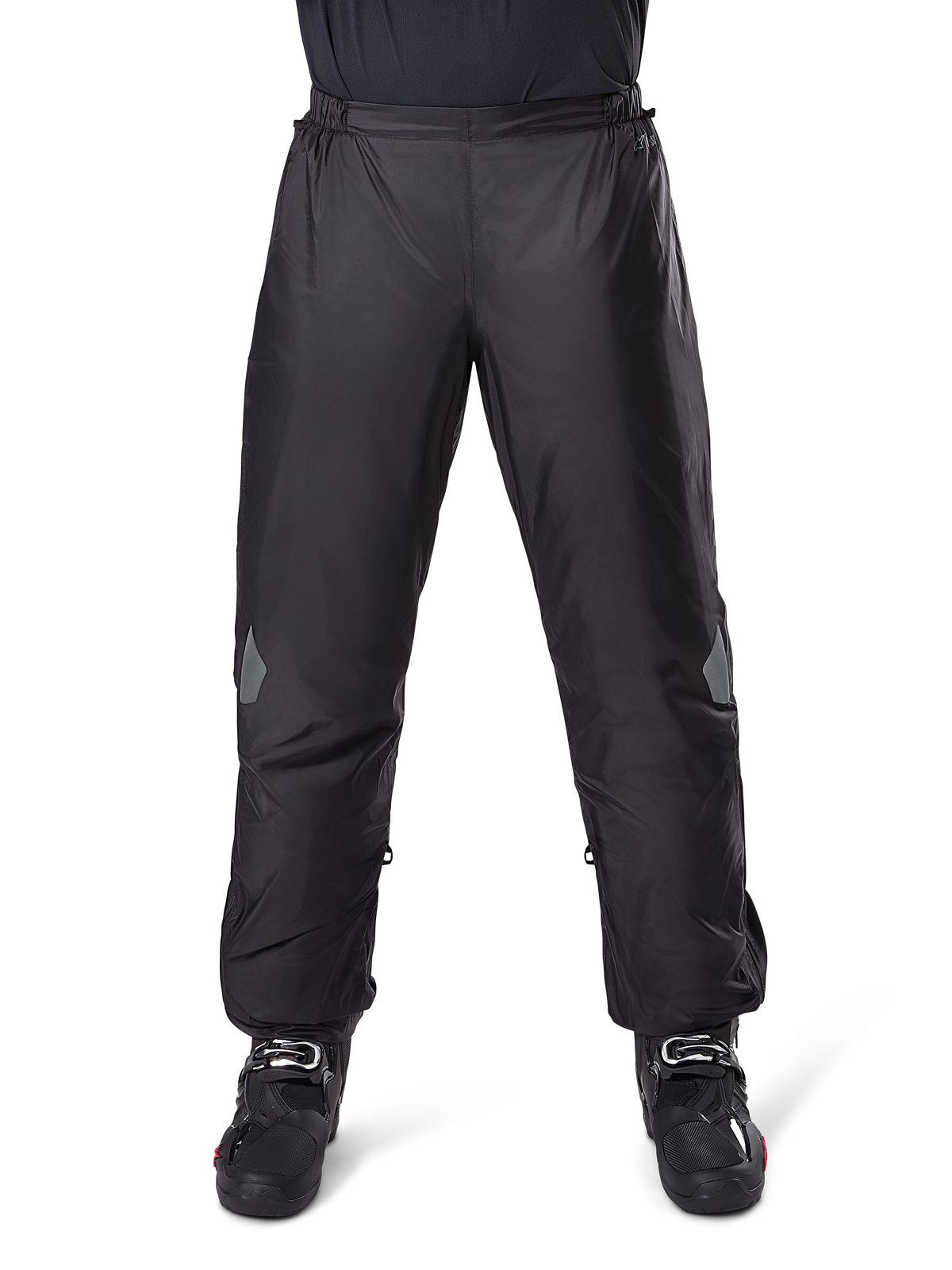 Alpinestars Bogota Pro Drystar 3-säsongsbyxor, vattentäta motorcykelbyxor, svarta, lätt tekniskt material med reflekterande knäpartier, bärs som överdragsbyxor med svarta MC-stövlar, designade för väderskydd vid äventyrskörning.