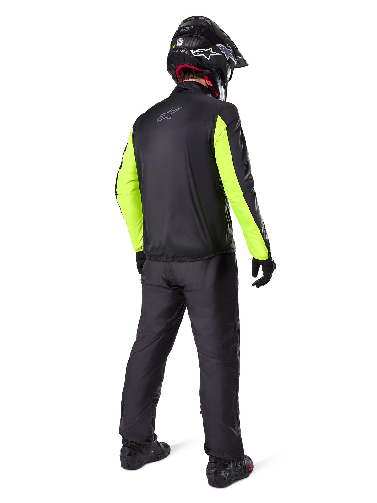 Förare sedd bakifrån i Alpinestars Bogotá Pro Drystar® 3 Seasons-byxor i svart, kombinerat med en svart jacka med fluorescerande gula ärmar, svart adventure-hjälm och stövlar, komplett adventure touring-utrustning