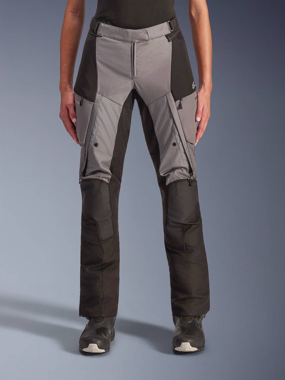Alpinestars Stella Andes V4 Drystar dambyxor, motorcykelbyxor för touring, grå och svarta, frontvy som visar lårventiler med dragkedja, cargofickor och förstärkta knäpartier, designade för äventyrskörning i alla väder