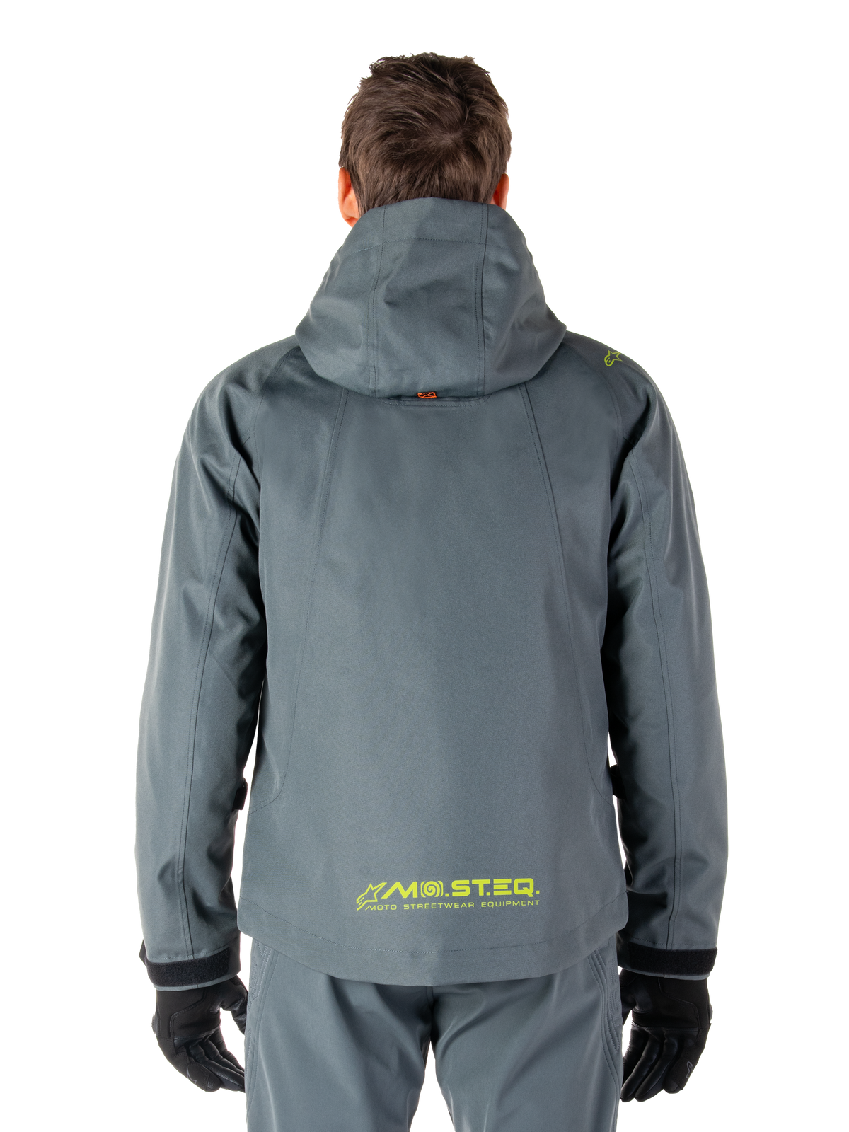 Alpinestars Morush Vattentät Parka, motorcykeljacka, Urban Gray, vy bakifrån som visar designen med huva och gul MO.ST.EQ.-logotyp på nedre delen av ryggen, modern urban streetwear-inspirerad motorcykelutrustning