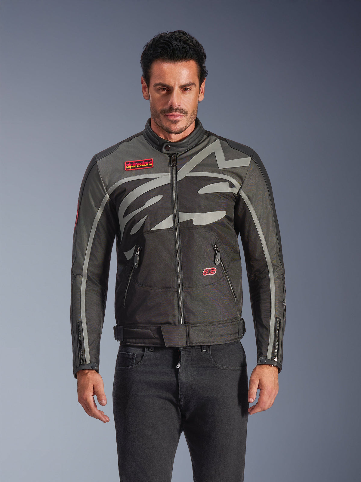Alpinestars Axton jacka, urban motorcykeljacka för män, svart och antracit med röda detaljer, stor omslutande ljusgrå grafik, röda logotypmärken på bröstet och fickan, dragkedja framtill och vid ärmsluten, vintageinspirerad racingdesign för stadskörning