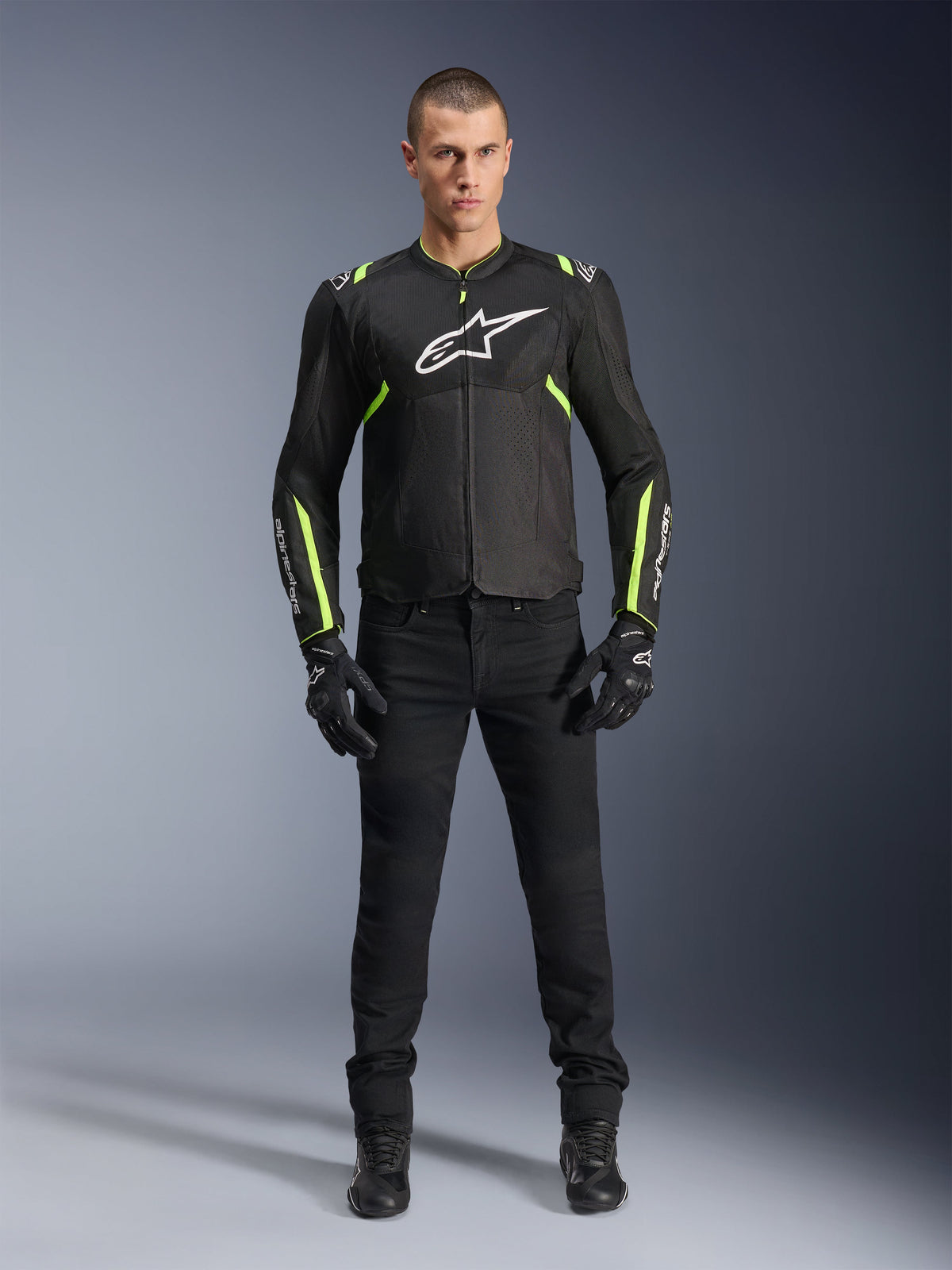 Alpinestars T-Sps Air V2 Jacka, svart och neongul, textiljacka för motorcykel med meshpaneler, bärs av manlig modell med svarta byxor och handskar, vit Alpinestars-logotyp på bröstet, urban sportkörutrustning