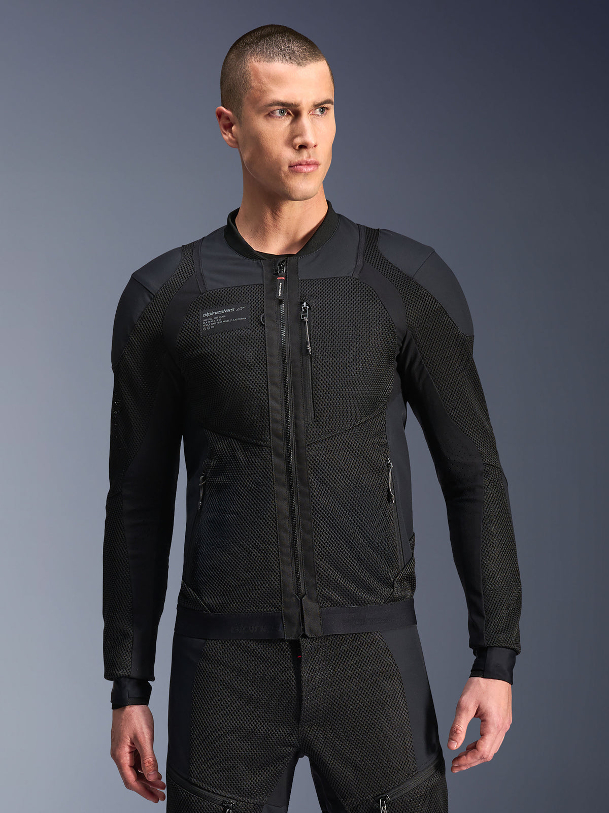 Alpinestars Troop-Air Pro-jacka, svart motorcykeljacka i mesh, manlig modell som bär bepansrad luftjacka med 2D-tech-mesh-struktur, dragkedja fram, fickor med dragkedja, teknisk skyddsutrustning för körning