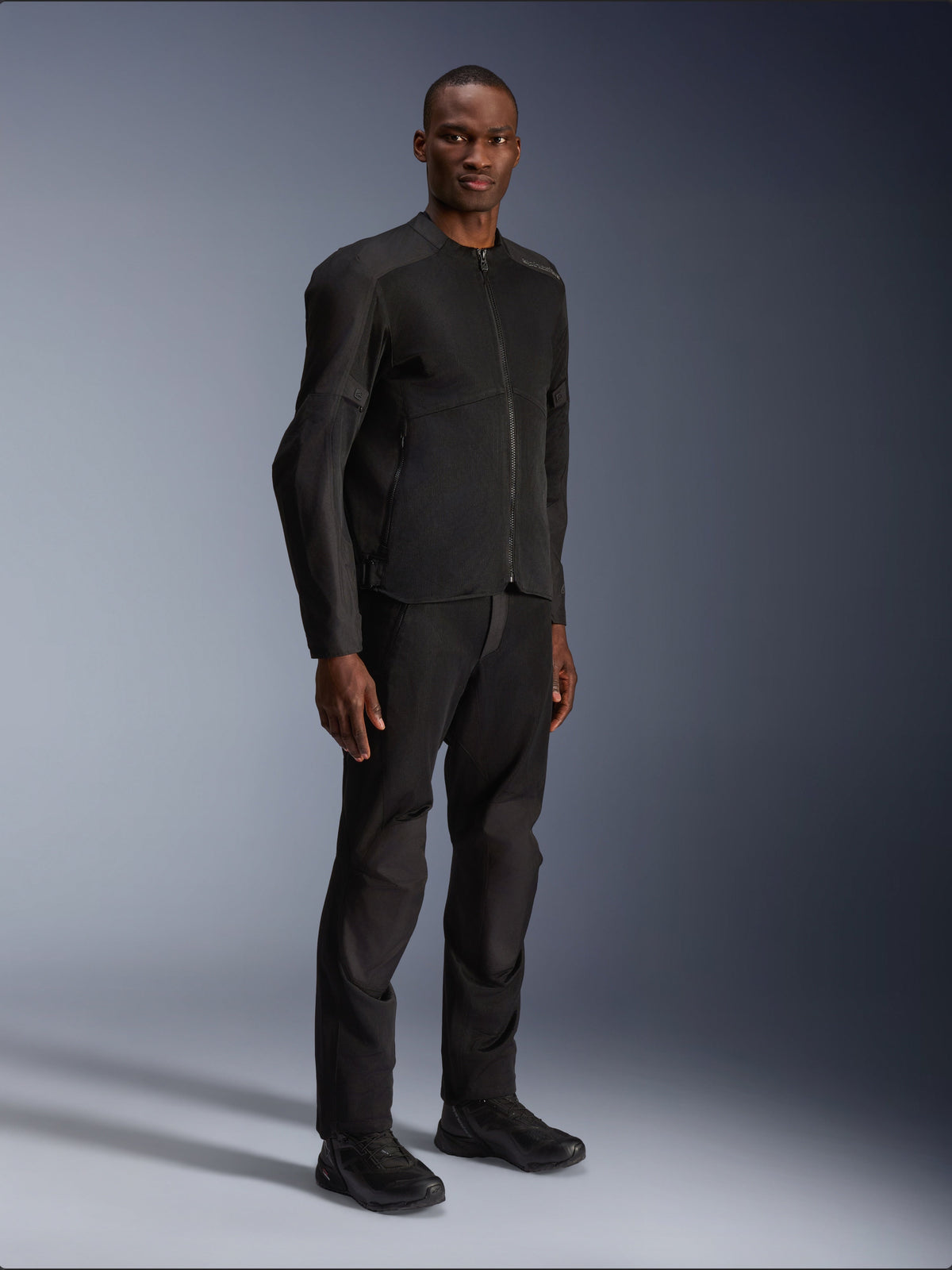Alpinestars C-1 Air Jacket, Black, worn by a model with matching black motorcycle pants and shoes, featuring large tech mesh panels for airflow, clean urban aesthetic with a streamlined fit.