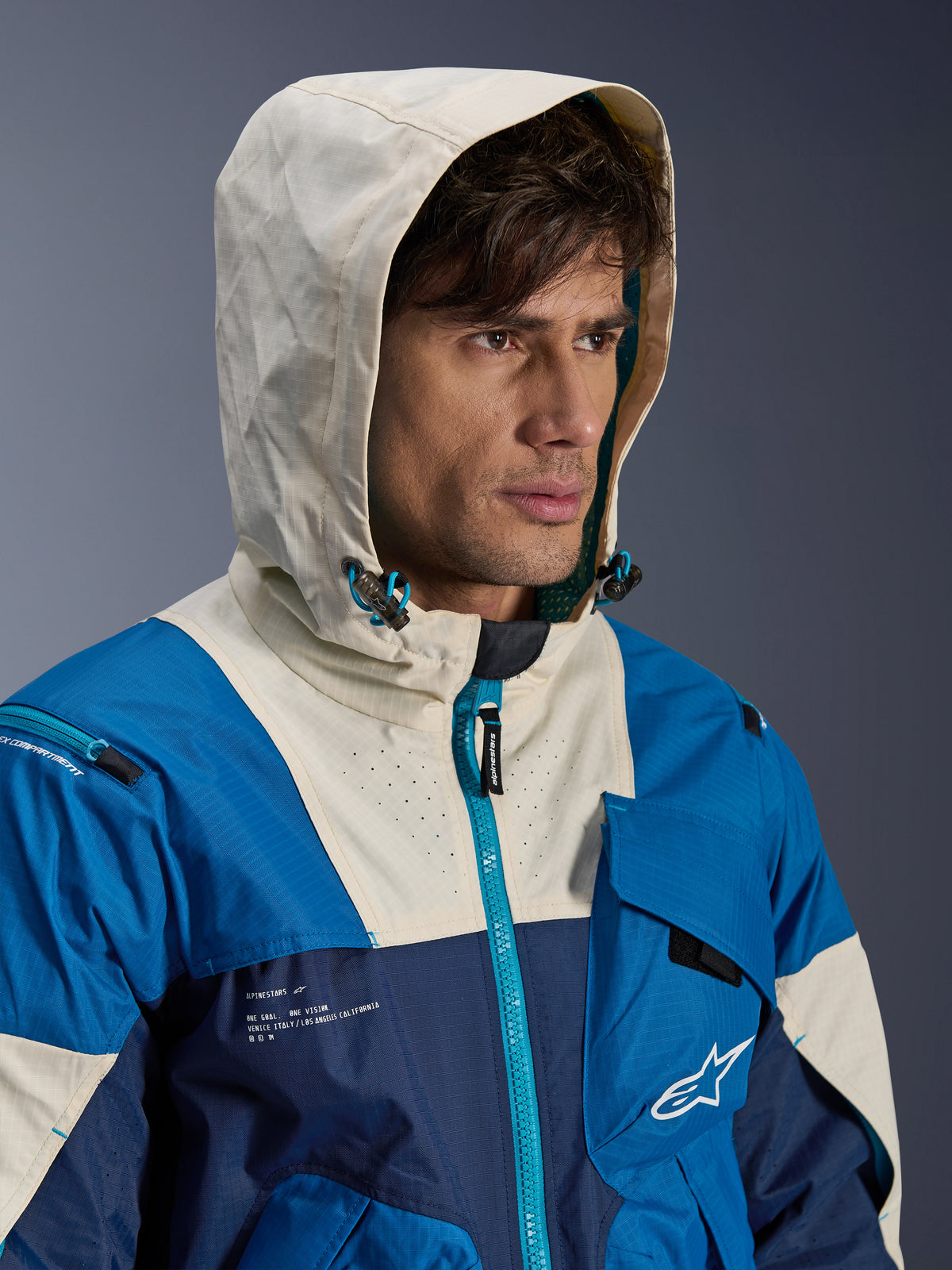 Alpinestars Mogress Air-jacka, ventilerad urban motorcykeljacka i textil för herrar, blå och almond, med huvan uppfälld.