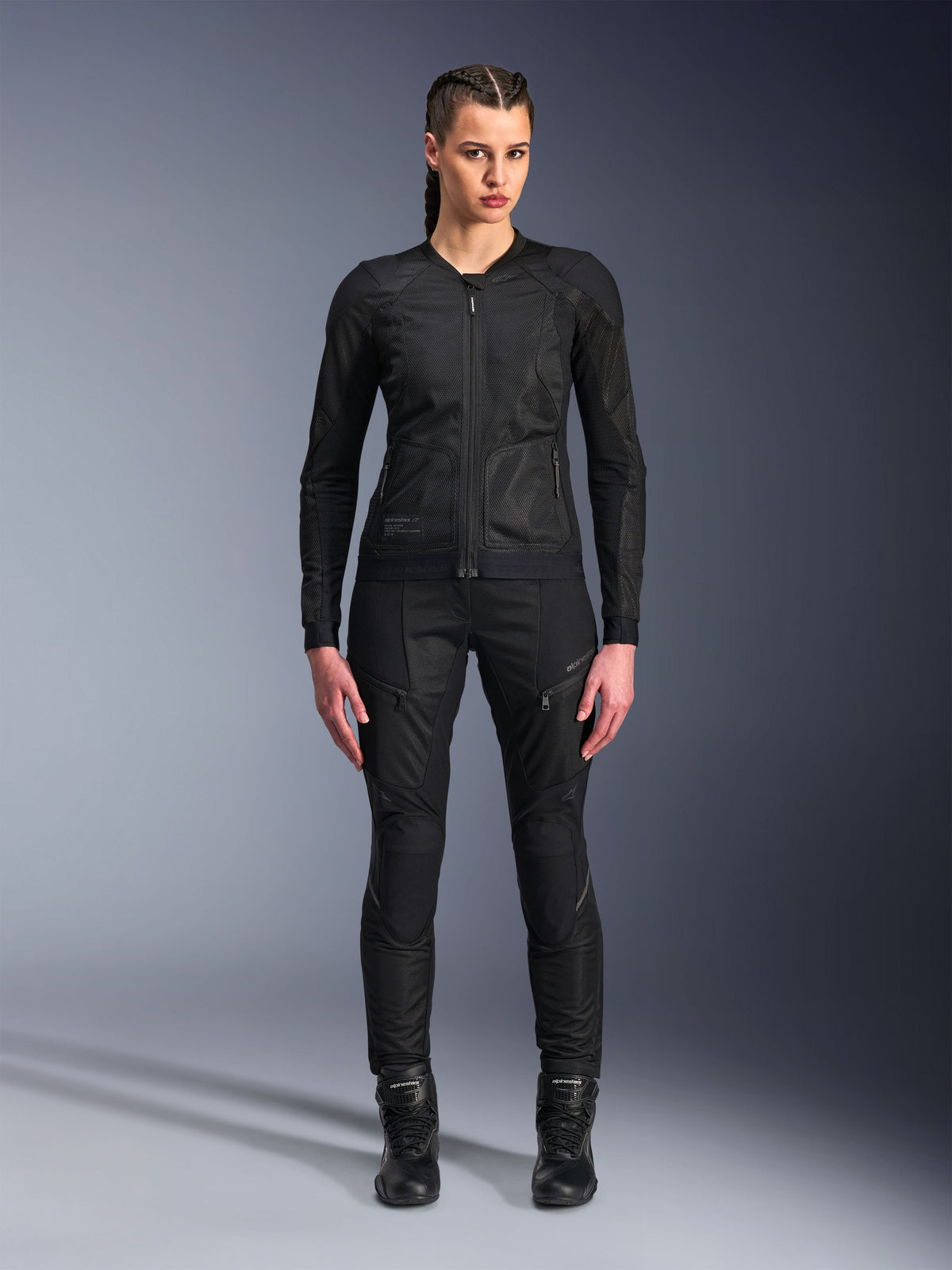 Alpinestars Stella Troop-Air jacka, motorcykeljacka för dam, svart, teknisk 2D-meshkonstruktion med minimalistisk design, bärs med svarta mc-byxor och stövlar, modern urban motorcykelstil