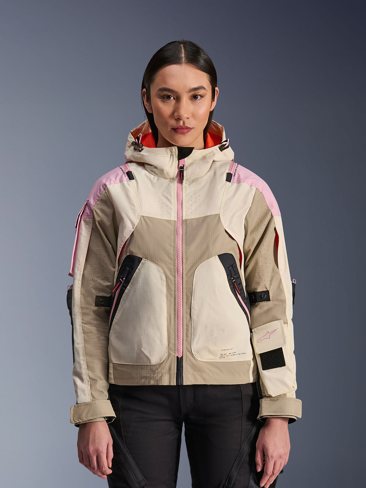 Alpinestars Molly Air Jacket, urban motorcykeljacka för dam, färgställningen Sand Pink Almond, design med huva, laserperforerad ventilation, rosa dragkedja och justerbara ärmremmar, visas på en modell.
