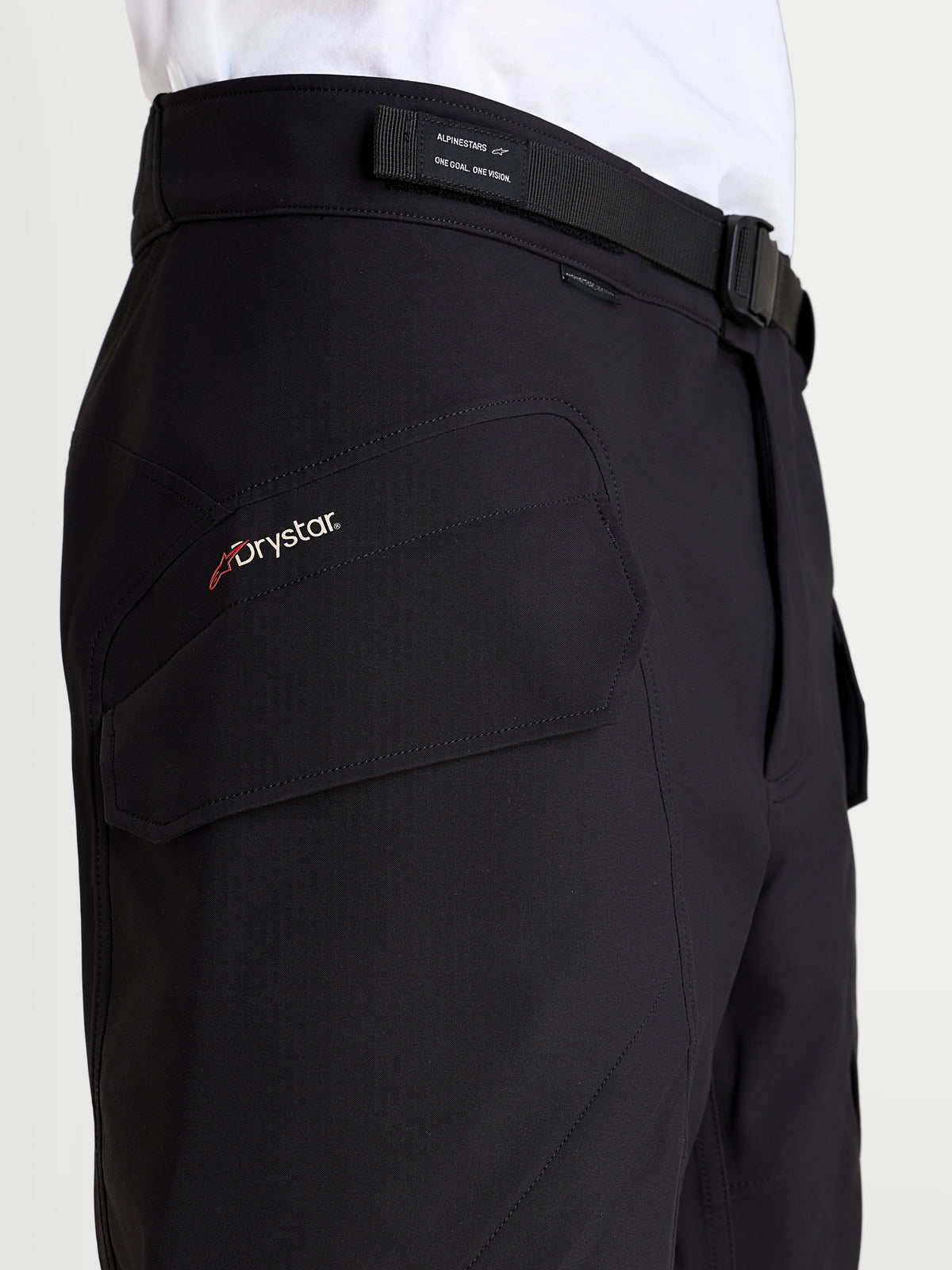Alpinestars Juggernaut V2 Drystar byxor, svarta vattentäta mc-byxor för herr, närbild som visar sidofickan med Drystar-märke och justerbart midjebälte