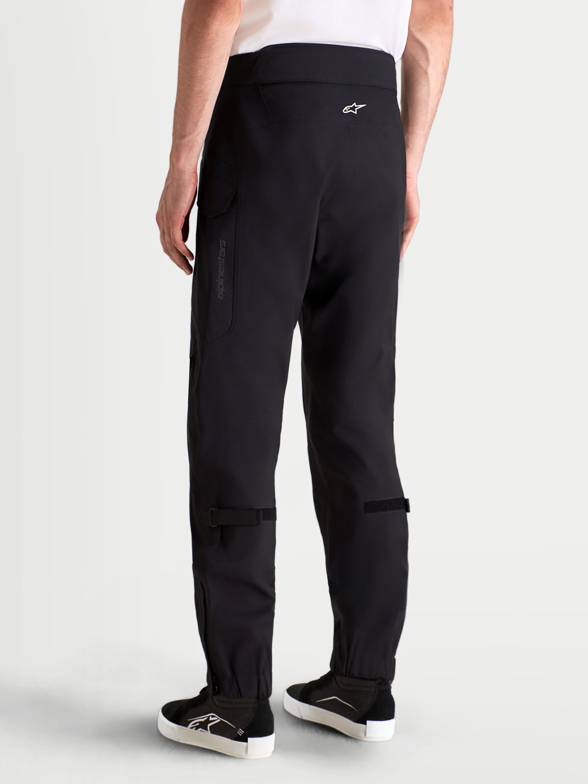 Alpinestars Juggernaut V2 Drystar byxor, svarta vattentäta mc-byxor för urban körning för herr, vy bakifrån på modell som visar hög midja och cargo-fickor