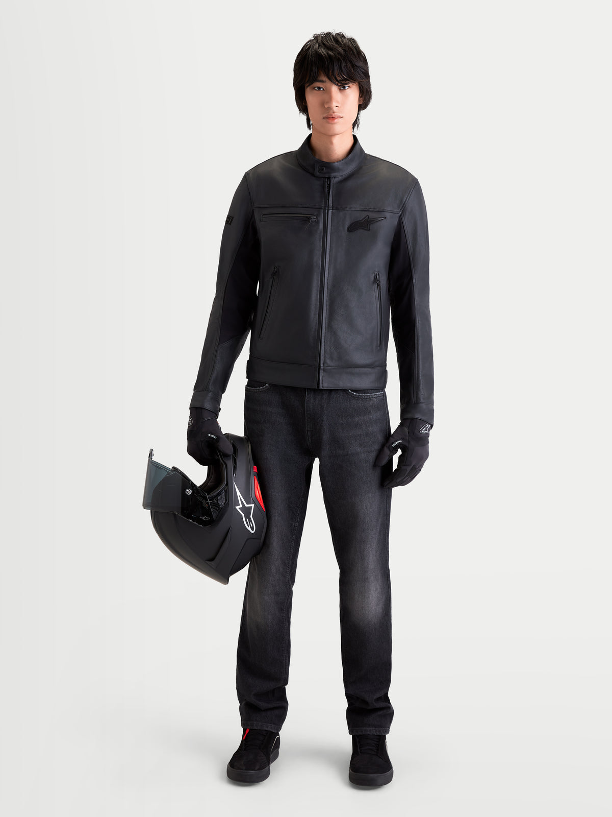 Alpinestars Flex Ast 7 Denim byxor, urban motorcykeljeans för herr i urtvättad svart, bars av en modell som håller en hjälm och matchande utrustning
