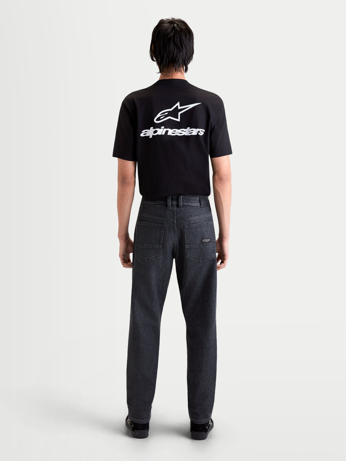 Alpinestars Flex Ast 7 Denim byxor, svarta urban motorcykeljeans för herr, vy bakifrån som visar enkellagers teknisk denim, femficksdesign och lädermärke på modell