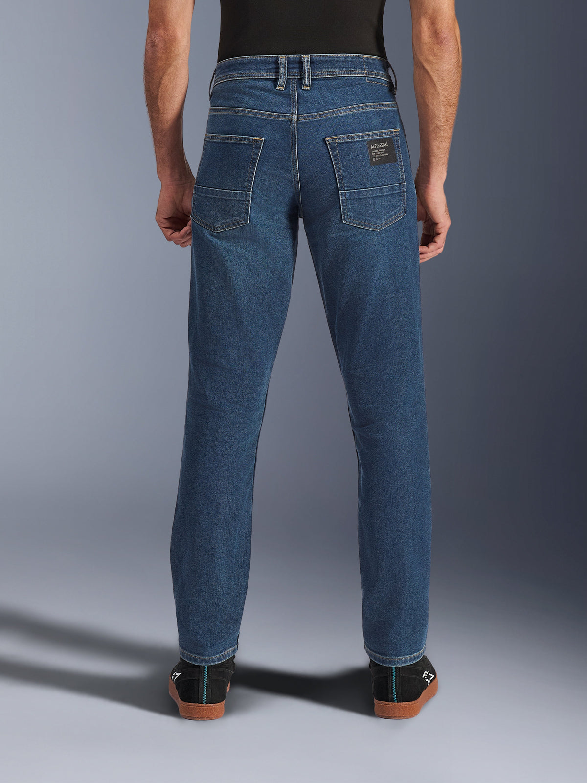 Alpinestars Flex-AST 5 Denim Pants, urbana motorcykeljeans för herr i tvättad indigoblå, vy bakifrån som visar avsmalnande passform, bakfickor med märkespatch och stretchjeanskonstruktion.