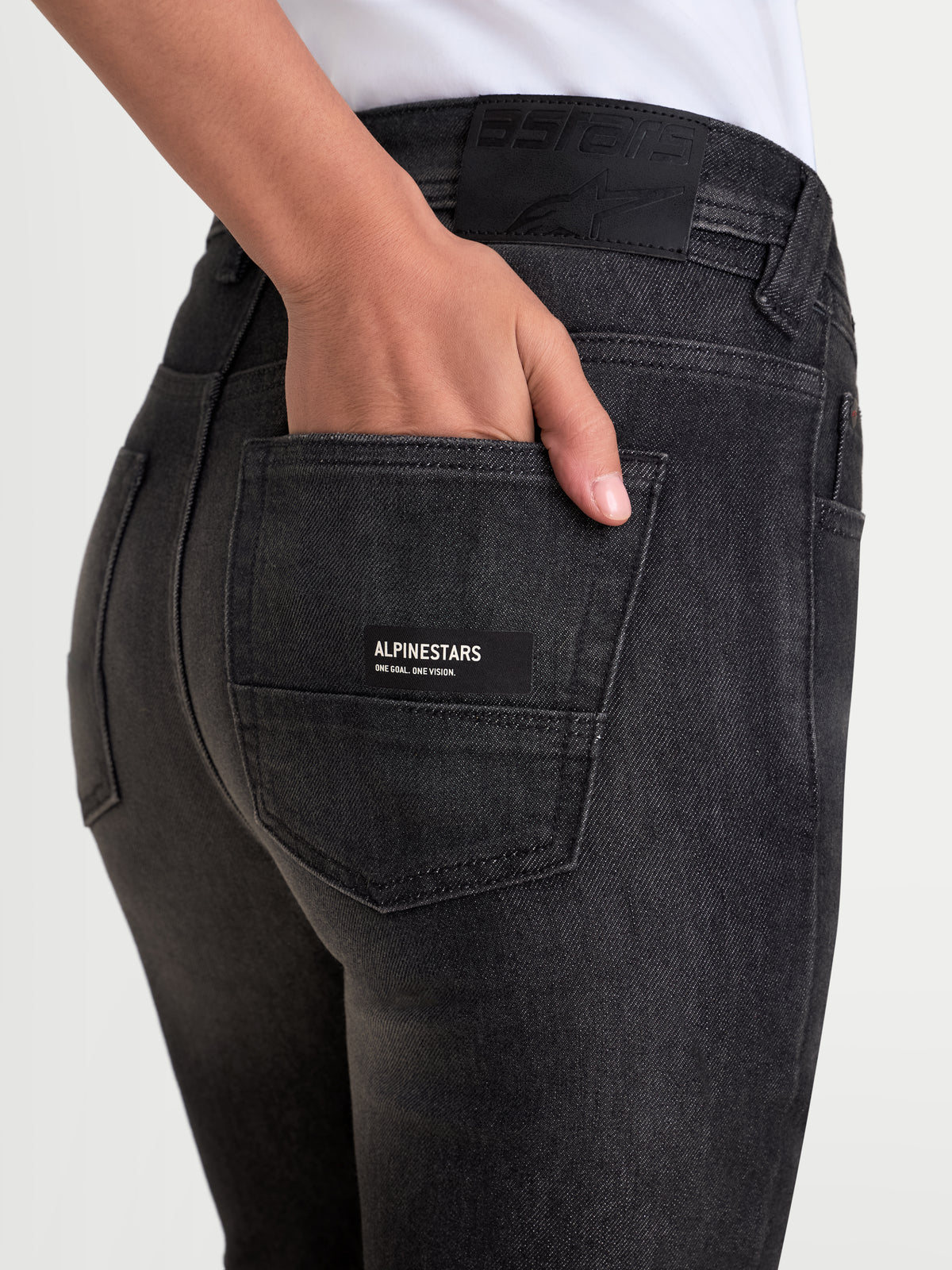 Alpinestars Stella Flex-AST 7 Denim Pants Short, women's urban motorcycle riding jeans, faded black, close-up rear view showing five-pocket construction, leather back patch, and branded pocket label worn by a model