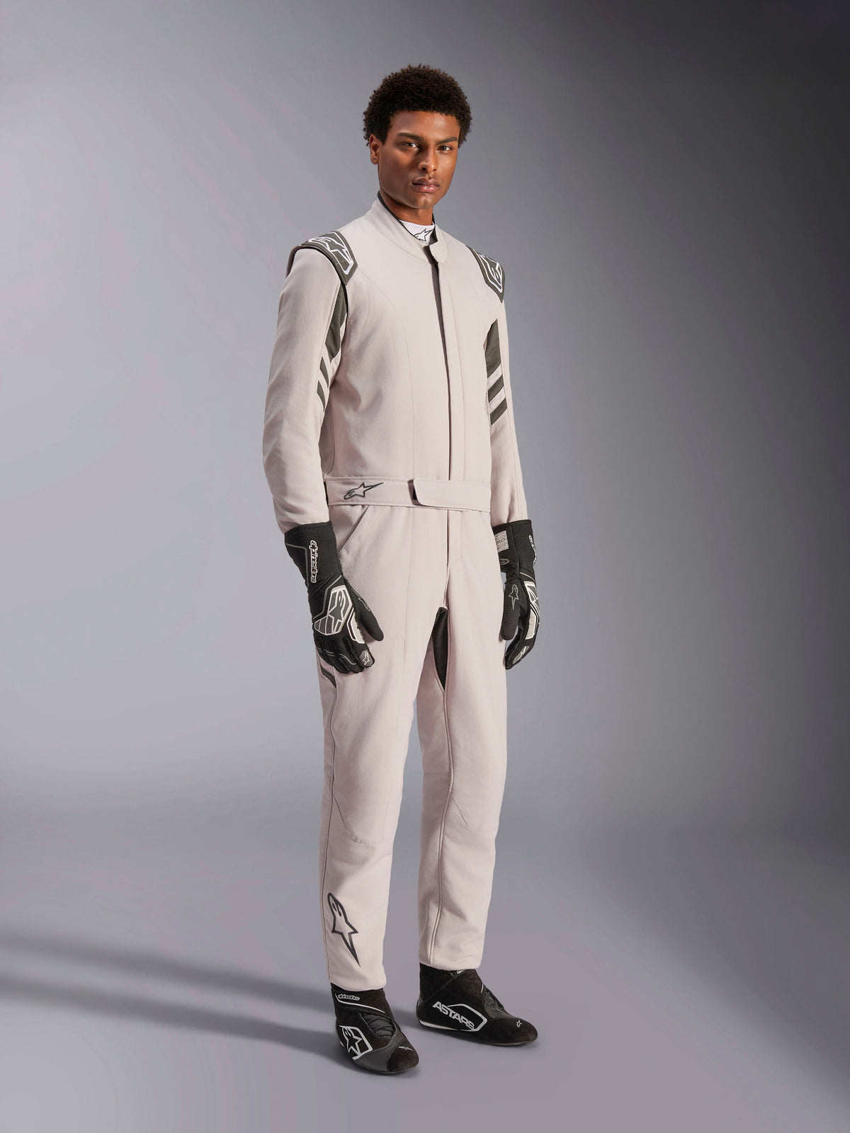 Alpinestars GP Race V3 Suit FIA, racingoverall i Silver Anthracite, föraroverall i ett stycke med axelklaffar och bälte i midjan, bärs med matchande svarta och vita racinghandskar och skor, stilren design för professionell bilsport