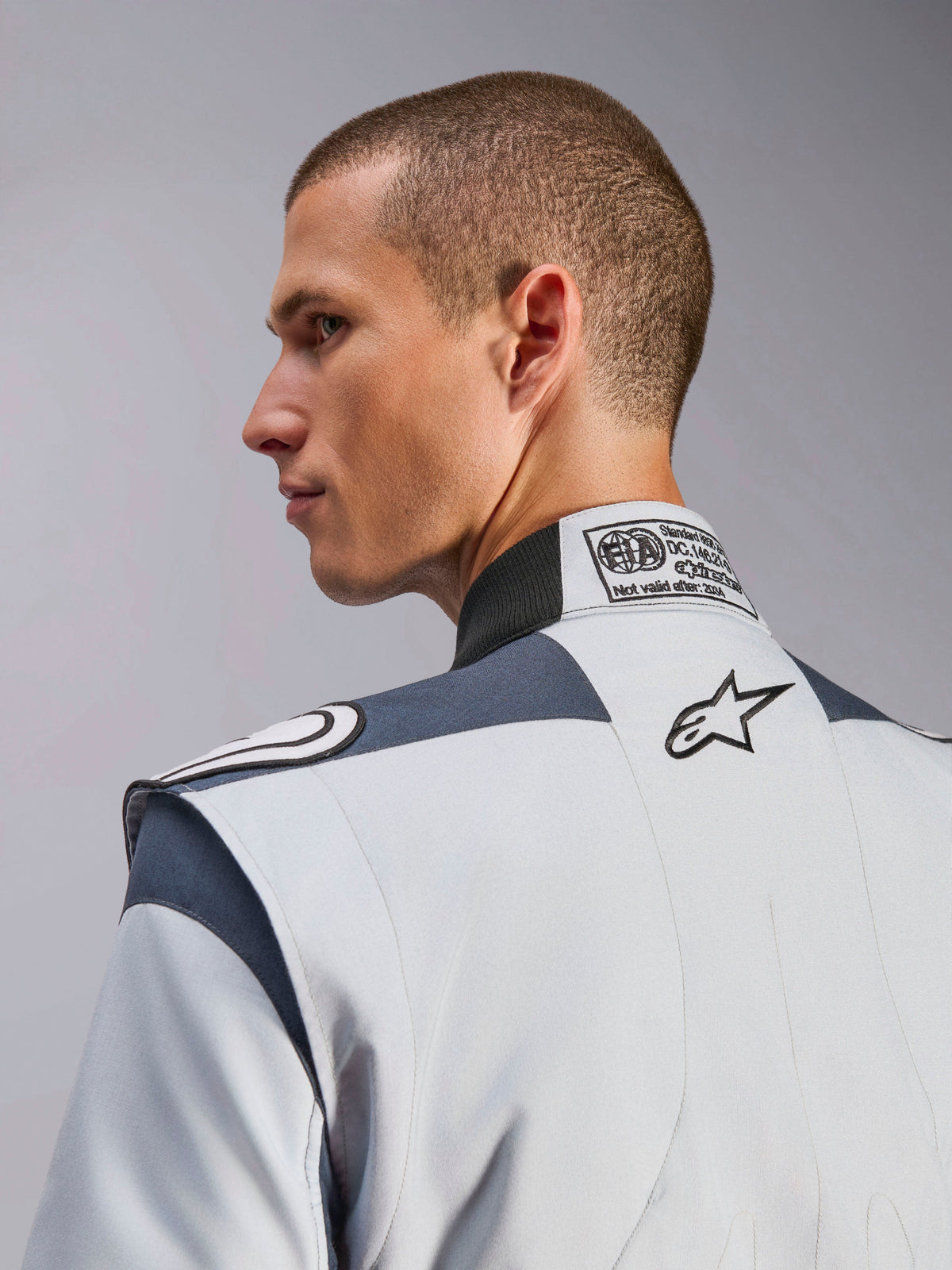 Alpinestars GP Pro Comp V2 mc-ställ, silver och grå racingoverall med FIA-certifieringsetikett och broderad logotyp.
