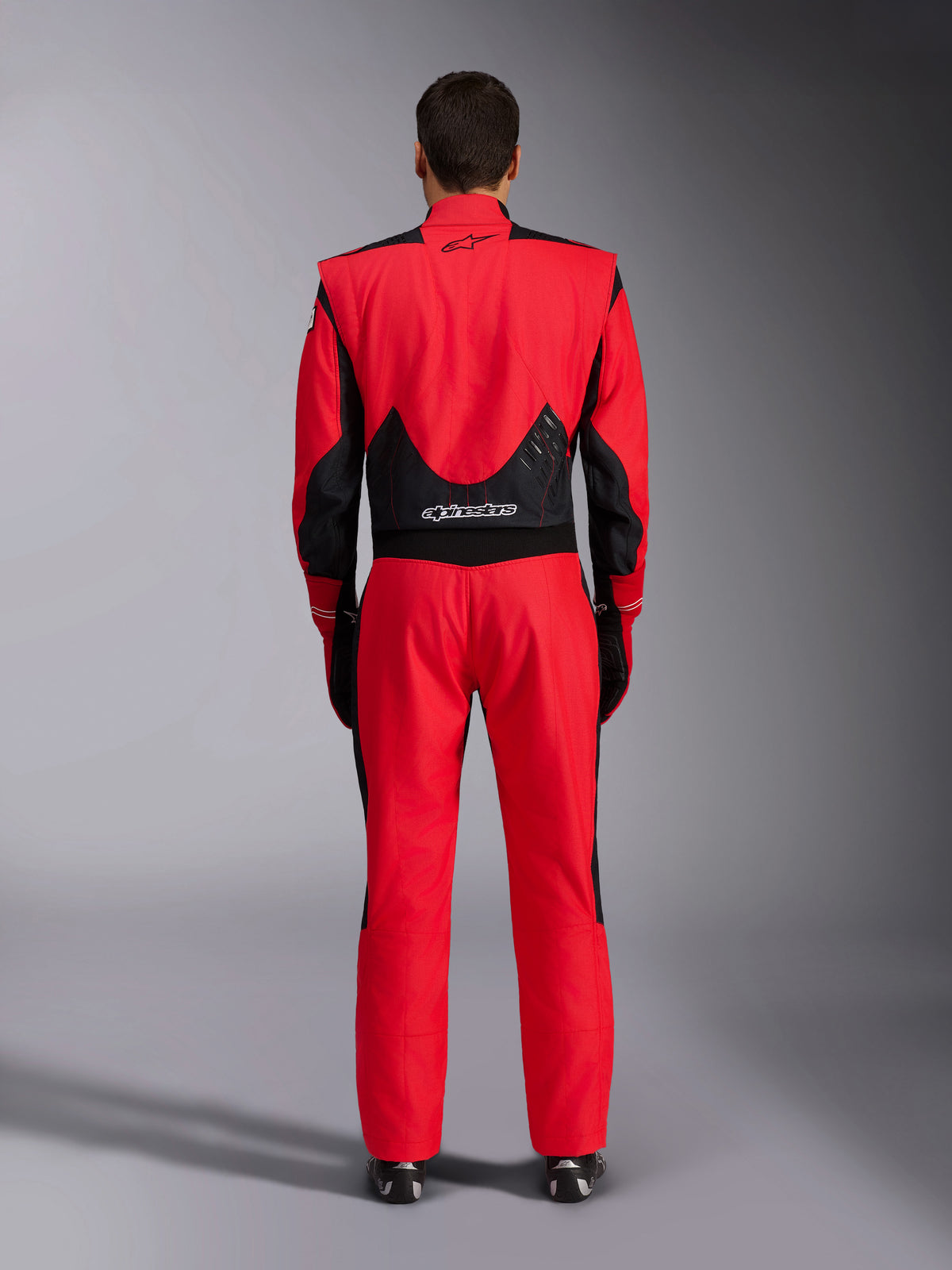 Alpinestars GP Pro Comp V2 FIA racingoverall, röd och svart, vy bakifrån som visar svarta mesh- och stretchpaneler på nedre ryggen, Alpinestars-logotyper på övre och nedre ryggen, professionell bilracingutrustning