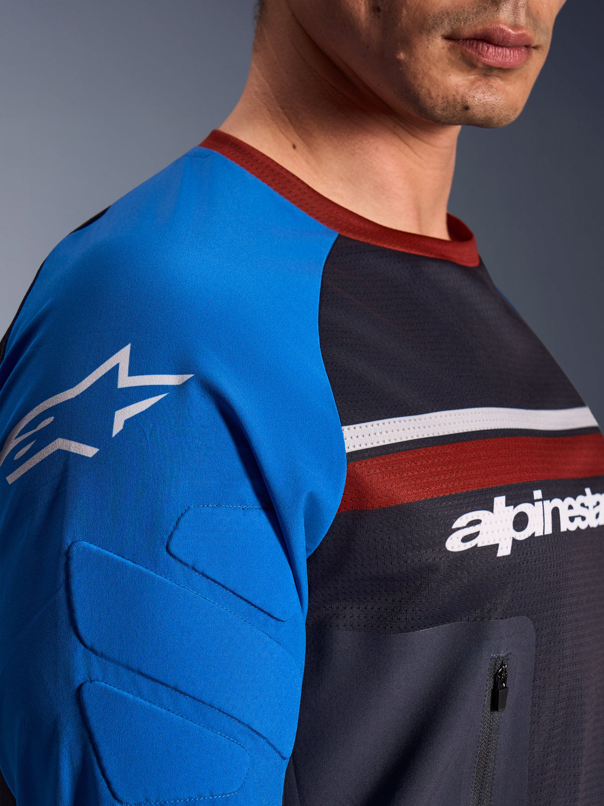 Alpinestars Maxdura Dual Jersey, Motorcycle Jersey, Deep Gray and Royal Blue, close-up view showing zippered chest pocket, mesh torso fabric, and integrated sleeve padding with star logo