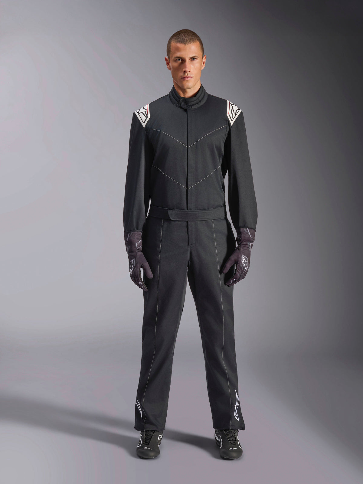 Alpinestars Kart Indoor V2 Suit, kartingoverall i ett stycke, svart, med vita Astars-logotyper på axlarna och underbenen, justerbart midjebälte och ergonomisk krage, designad för rekreationsinriktad inomhuskarting