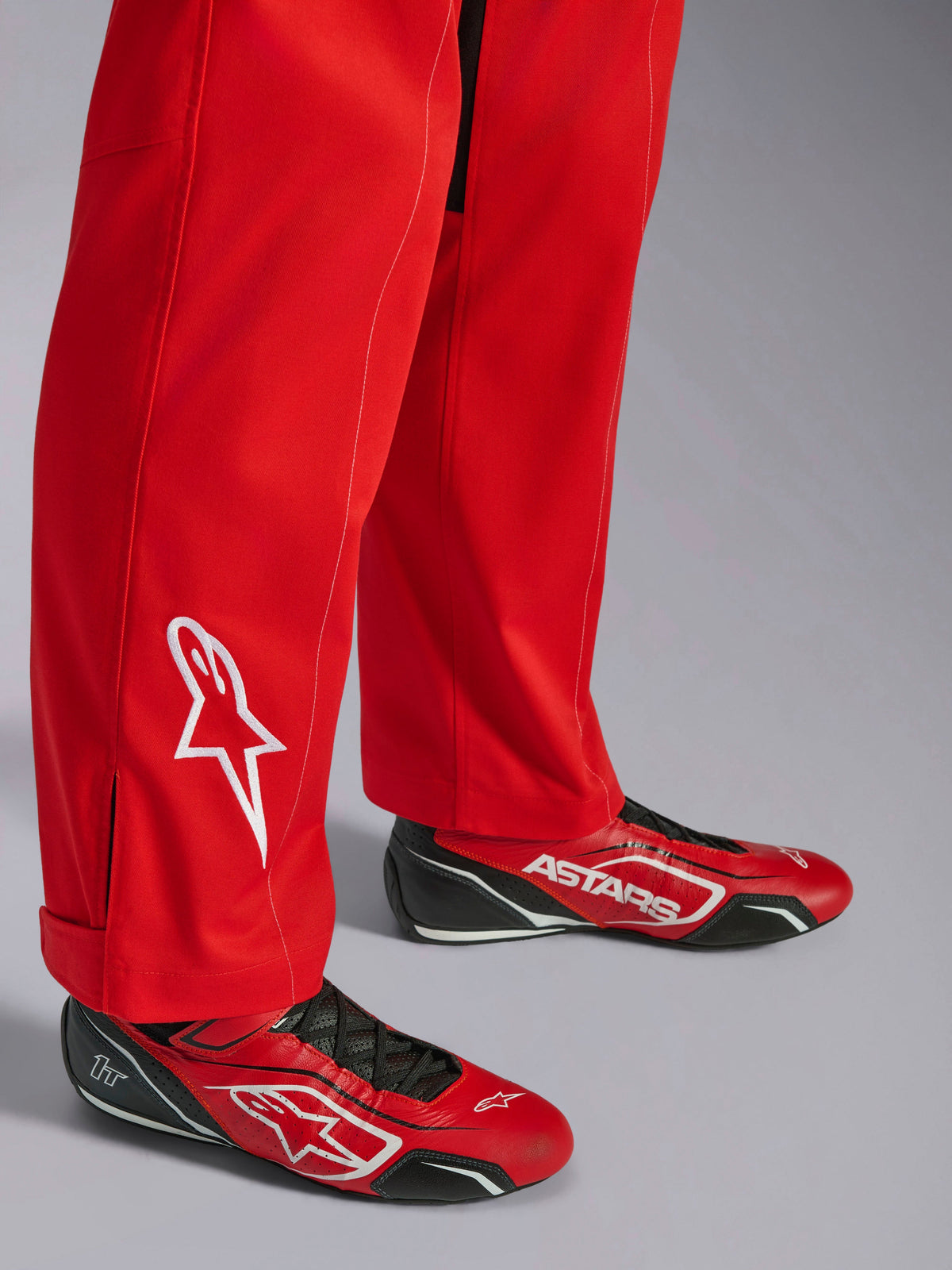 Alpinestars Kart Indoor V2 Suit, Red, lower leg detail with white embroidered star logo, worn with matching red and black karting shoes, single-layer poly-cotton twill material for recreational racing