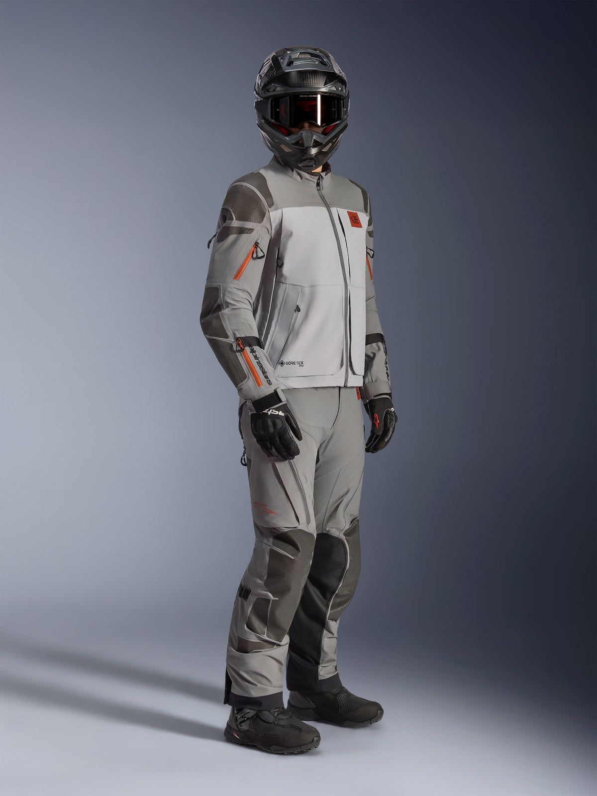 Alpinestars Nazca 3L GORE-TEX PRO-jacka, äventyrsjacka för motorcykel, mörkgrå och mellangrå, buren som en komplett outfit med matchande äventyrsbyxor, med orangea detaljer och Superfabric-förstärkningar, inkluderar svart äventyrshjälm och handskar, tekniska kläder för touring och off-road-körning