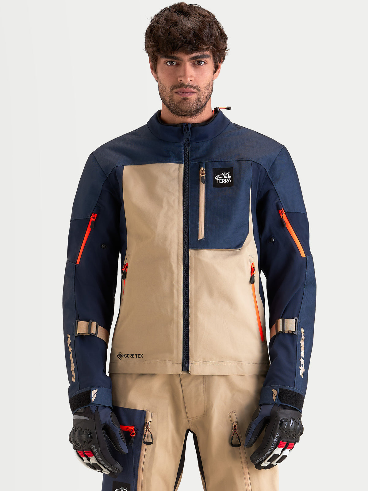 Alpinestars Arenis Gore-Tex jacka, äventyrsmotorcykeljacka för herr i mörkblått och aluminium, framifrån på modell iklädd matchande utrustning och handskar, vattentät textilkonstruktion