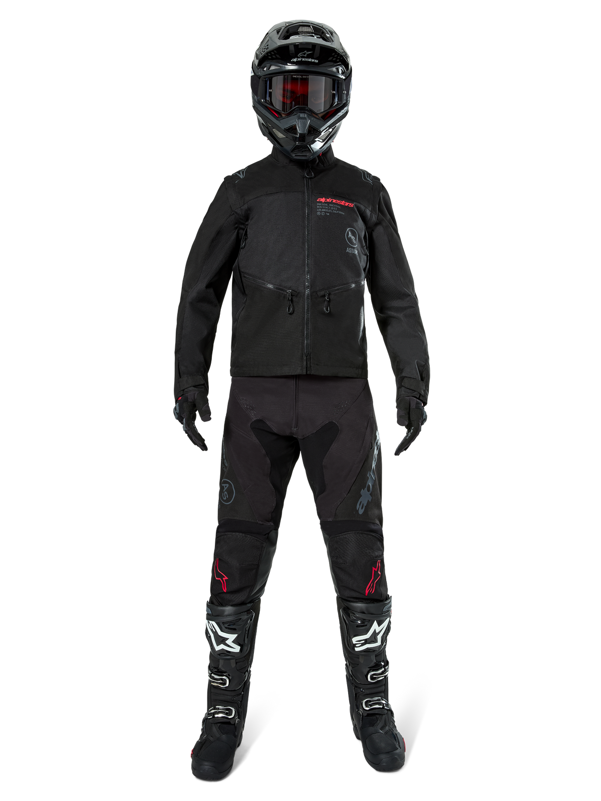 Alpinestars Pro-Dura jacka, svart offroad- och endurojacka, visas på en modell med komplett utrustning inklusive en svart hjälm med röda goggles, svarta byxor med röda detaljer, svartvita stövlar och svarta handskar, rallyinspirerad robust design för terrängkörning