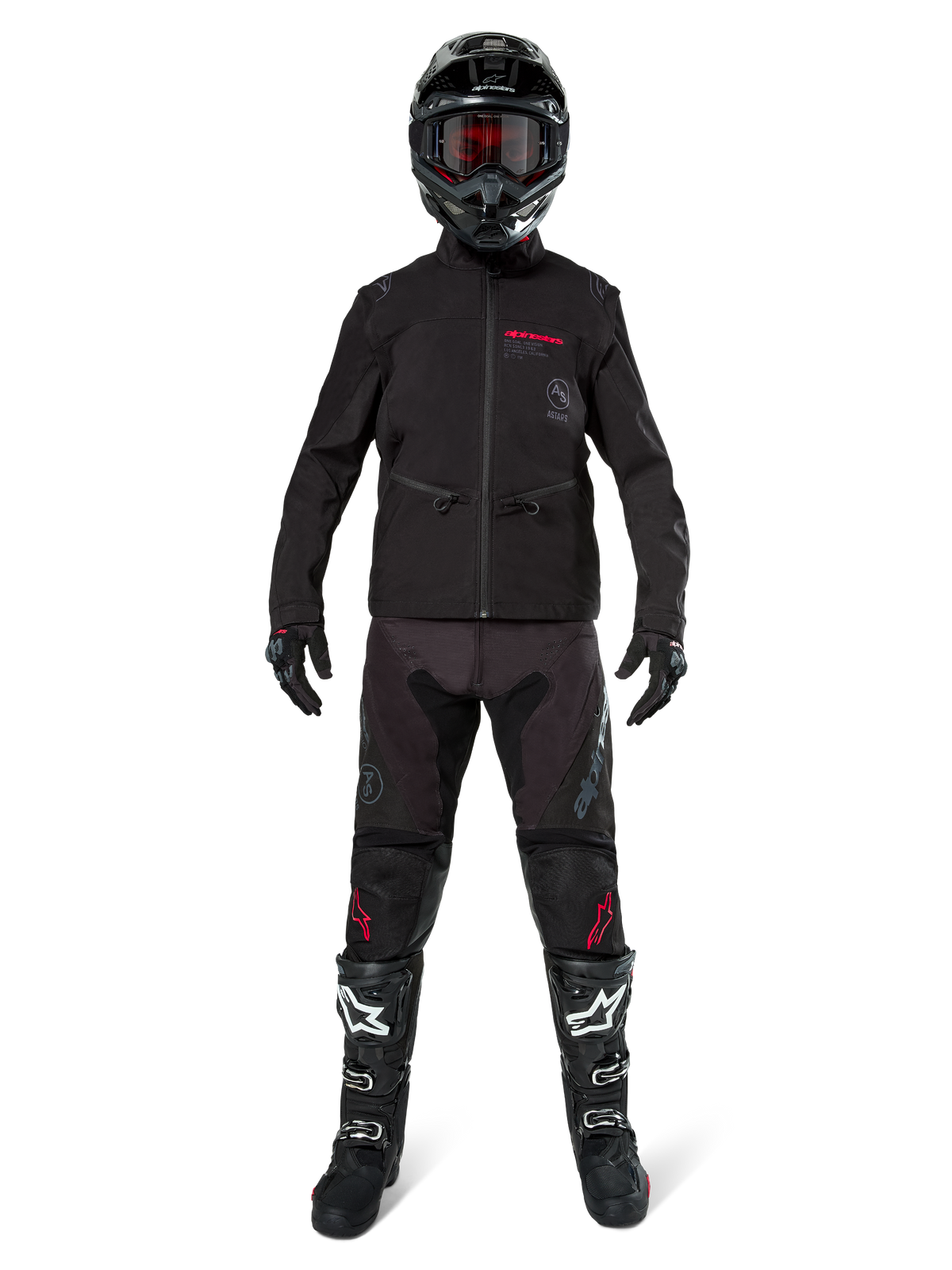 Motocrossförare i Alpinestars Lite-Dura Softshell-jacka i svart med röda logotypdetaljer, matchande svarta offroad-byxor, svart hjälm samt vita och svarta stövlar, komplett professionell enduro-utrustning
