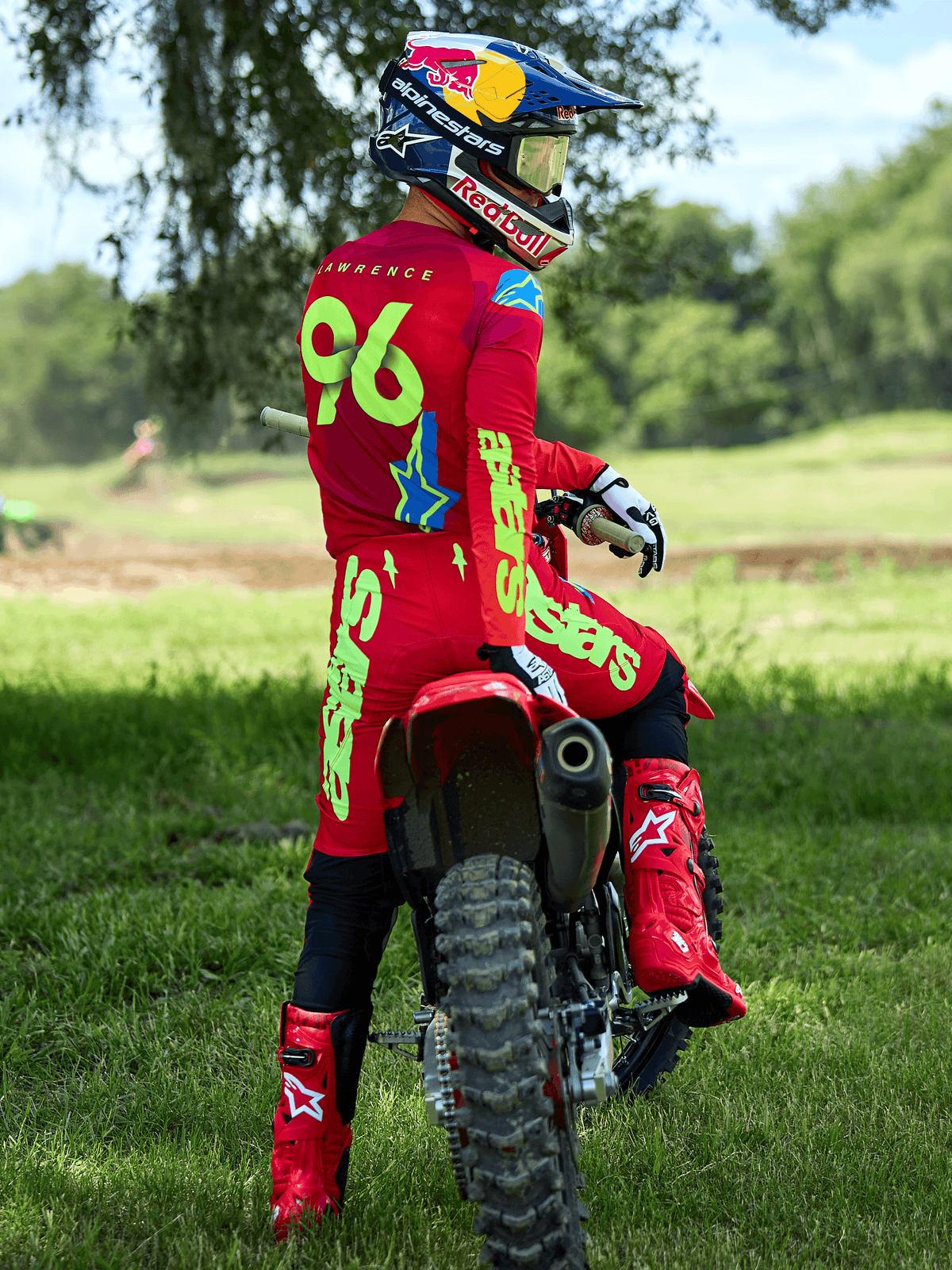 Motocrossförare klädd i Alpinestars 2025 Supertech Maker-utrustningsset i Bright Red och Yellow Fluo, sittande på en röd motocrosscykel, med tröjnummer 96, matchande röda stövlar och hjälm, professionell racingutrustning för terrängprestanda