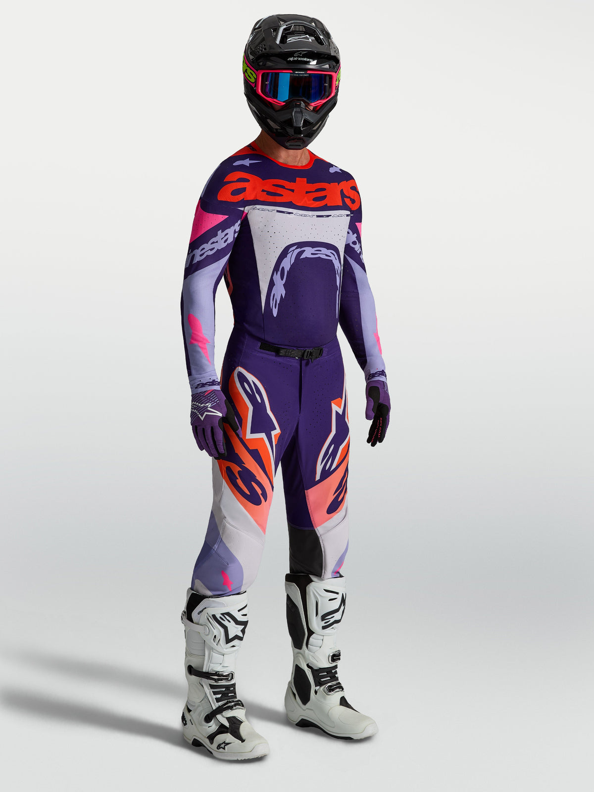 Alpinestars Supertech Dyna byxor, lila och rosa fluo motocrossbyxor för herr med matchande tröja och vita stövlar.