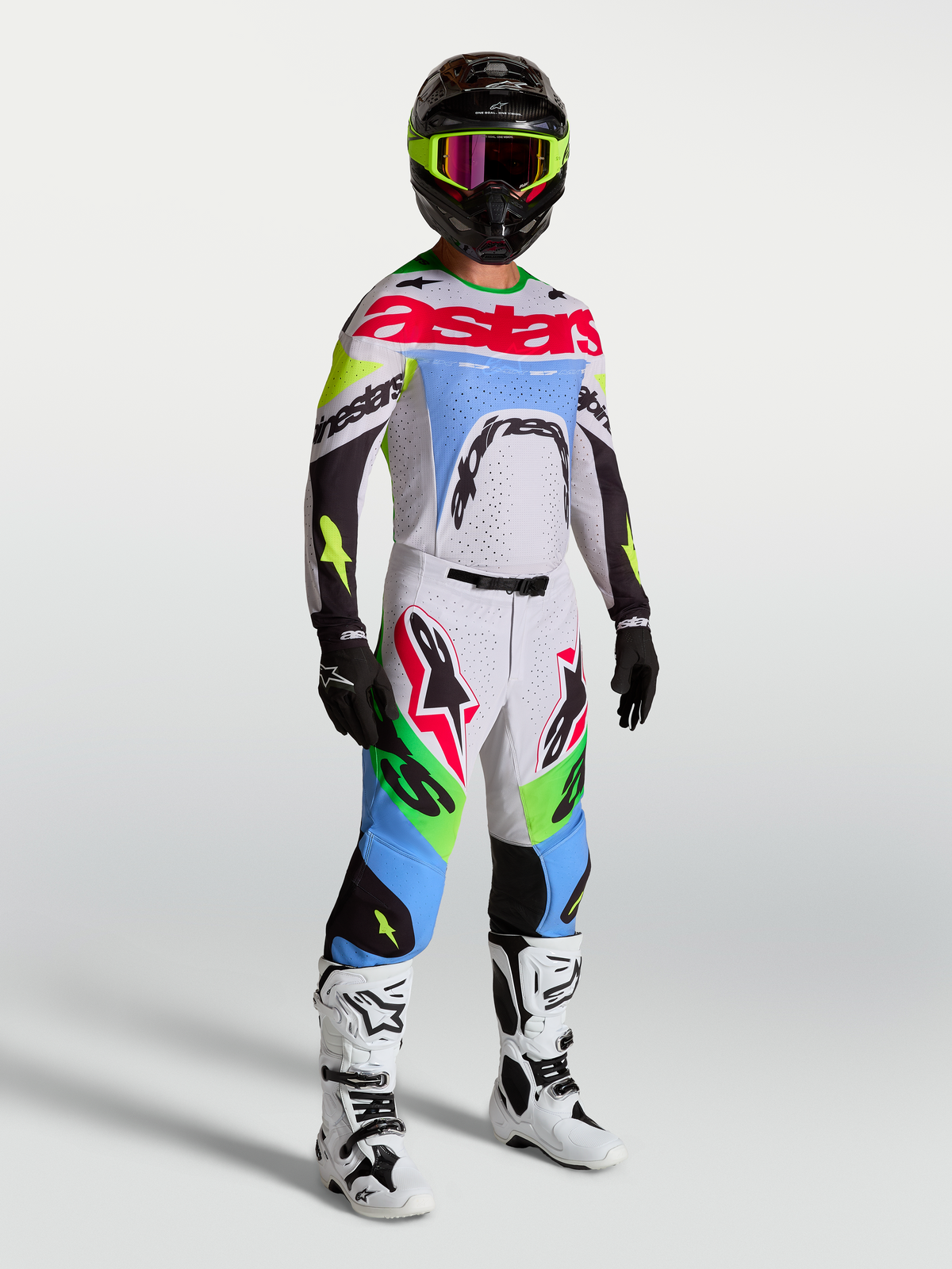 Alpinestars Supertech Dyna byxor, motocrossbyxor för herr, ljuslila och grön fluo, på modell i ett komplett racingställ.