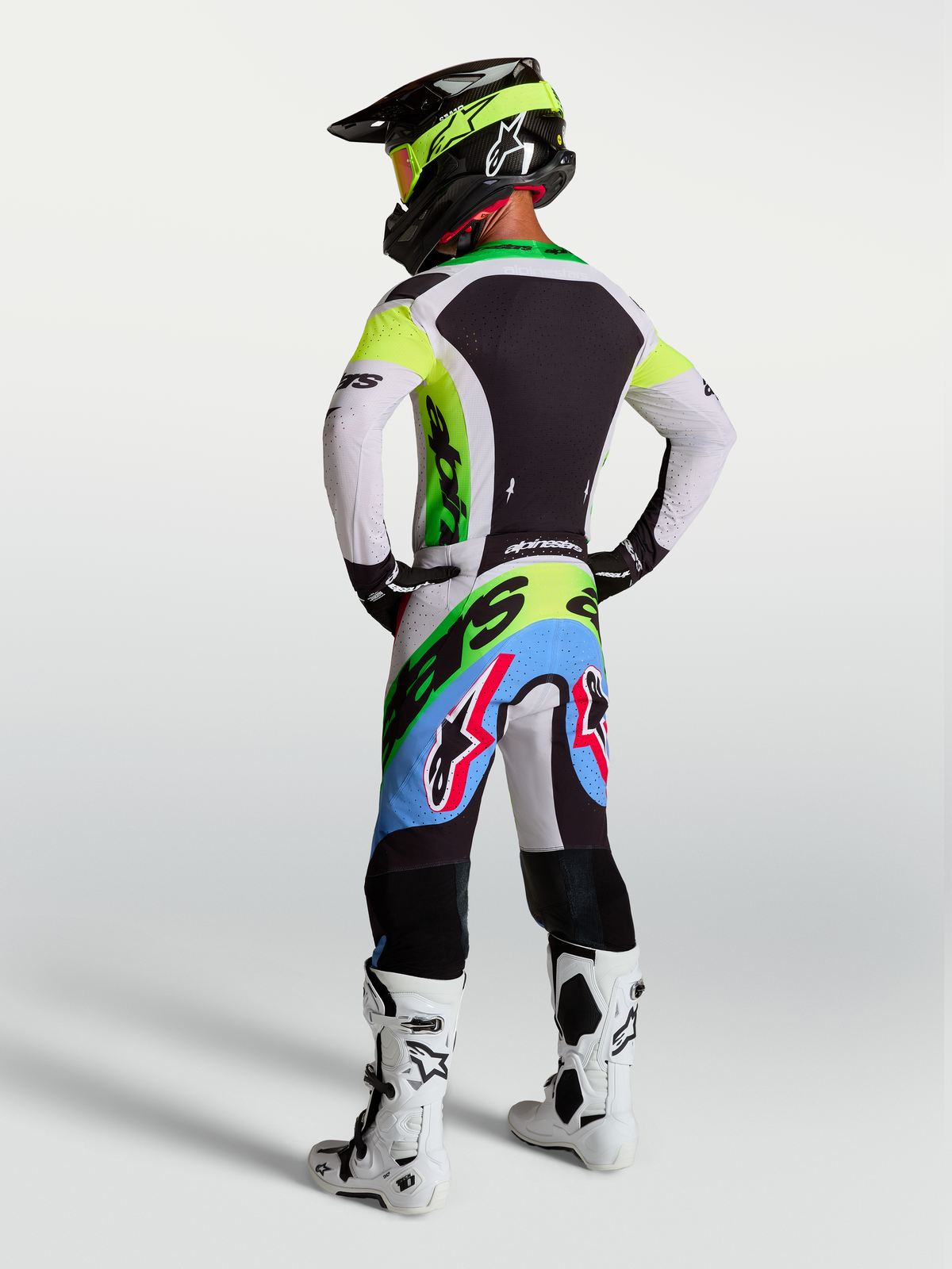 Alpinestars Supertech Dyna motocrossutrustning, grön fluo, svart och ljuslila, racingbyxor och tröja, vy bakifrån.