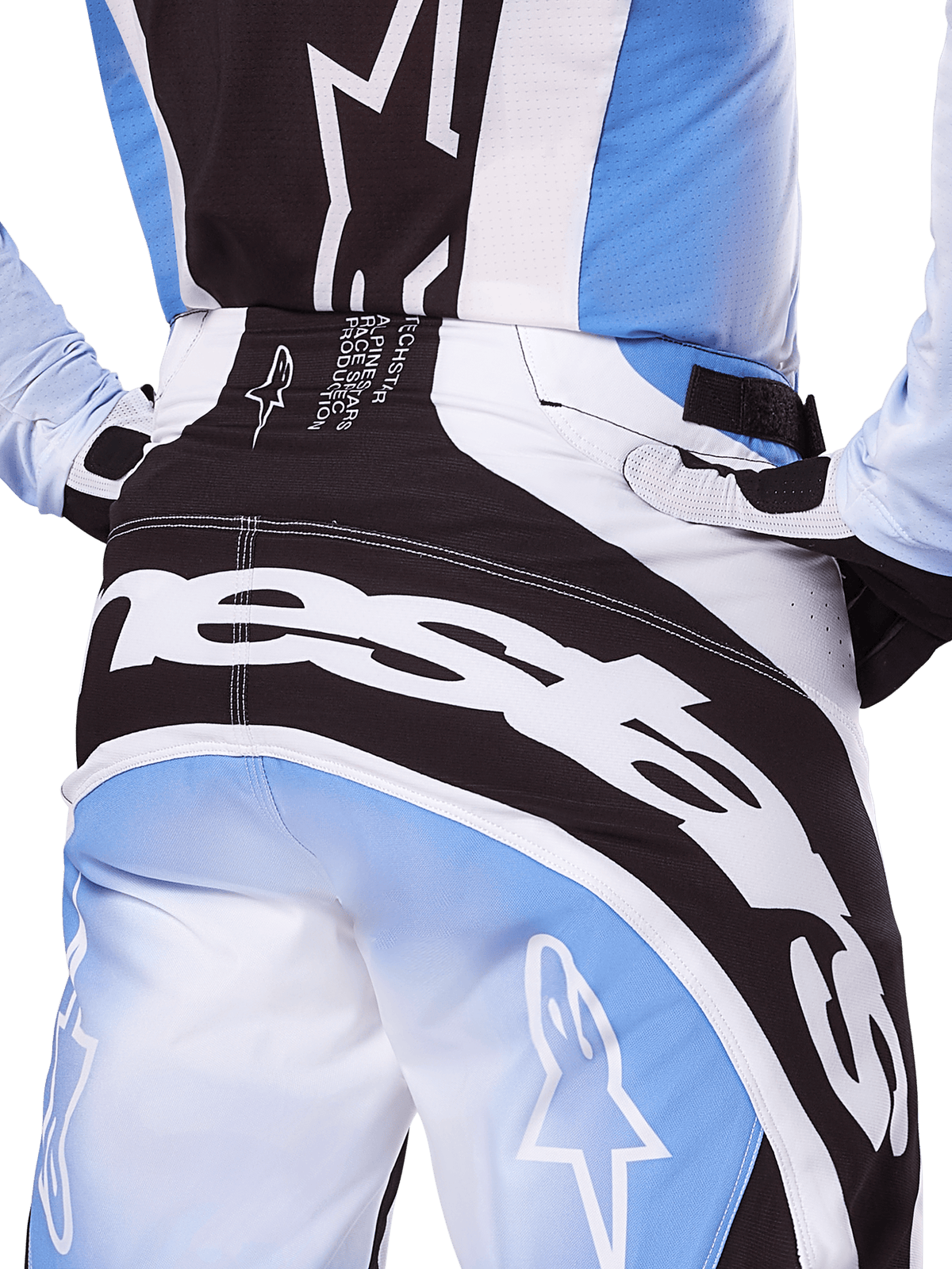 Alpinestars 2025 Techstar Melt byxor, motocrossbyxor, svarta, vita och blå, närbild bakifrån med framträdande vit logotyp på sätet, matchad med tillhörande Techstar Melt-tröja och handskar, professionell racingutrustning för motocross