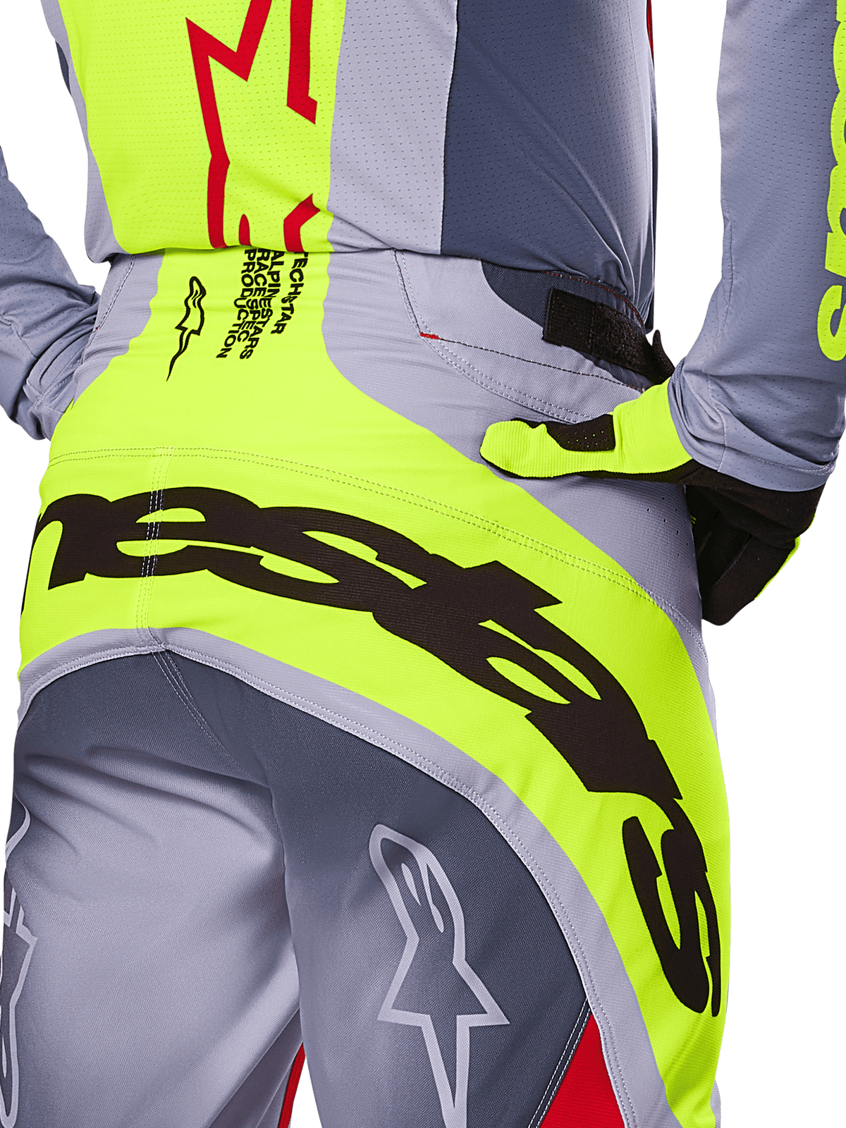 Alpinestars 2025 Techstar Melt byxor, närbild på sätet och midjeområdet, grå och neongul design med stor svart branding, stjärnlogotyper och race-spec-text, högpresterande motocrossutrustning