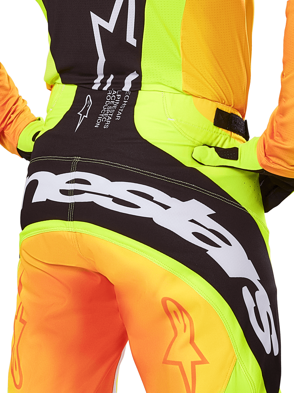 Alpinestars 2025 Techstar Melt byxor, motocrossbyxor, närbild bakifrån, neongul och orange med svarta paneler, stor vit Alpinestars-logotyp över sätet, högpresterande utrustning för terrängkörning
