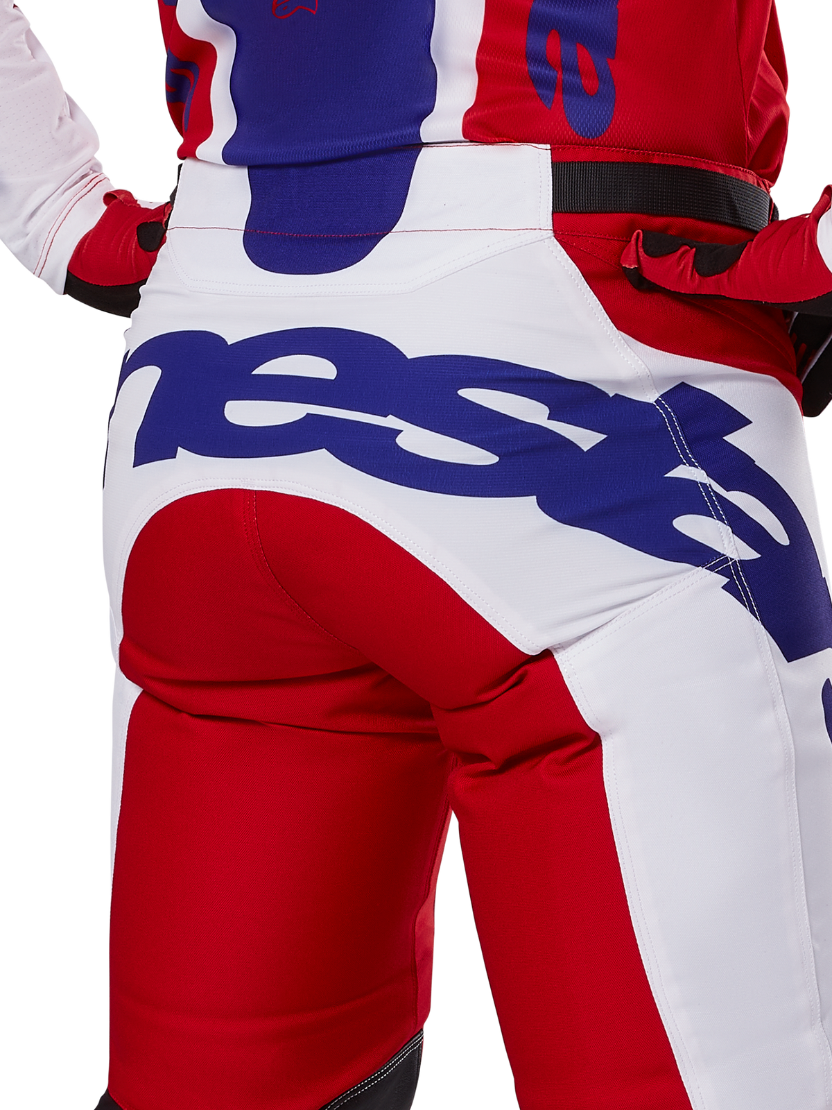 Alpinestars 2025 Racer Veil byxor, motocrossbyxor, klarröda och vita med blå logotyper, detaljbild bakifrån på sätespartiet med en stor Alpinestars-logotyp, bärs som en del av en matchande racingoutfit för terrängkörning